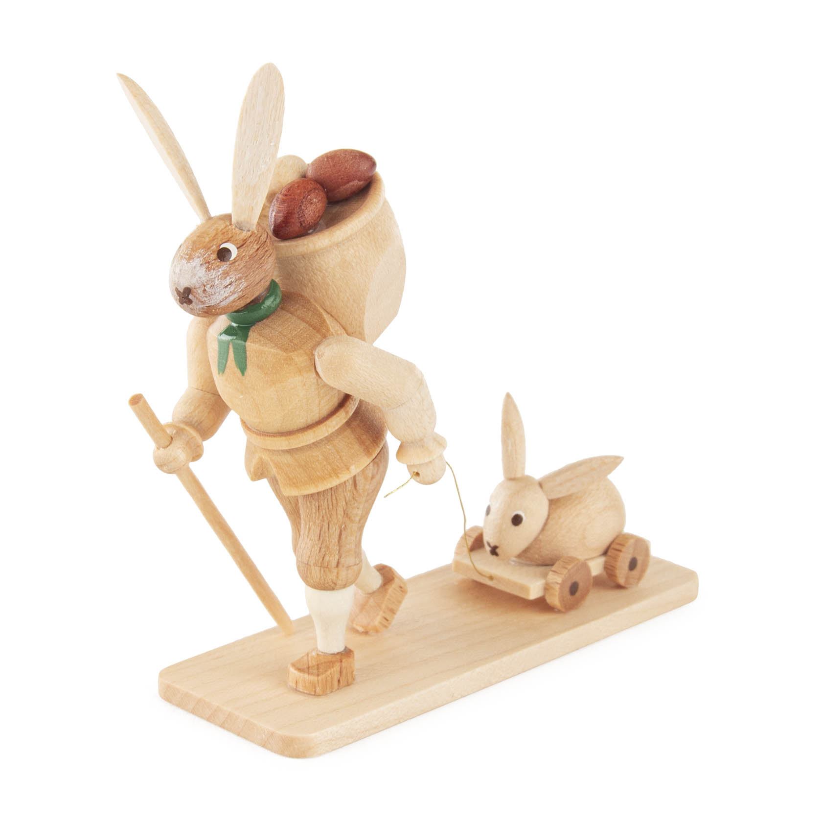 Hölzerner Osterhase auf Sockel, runnend mit einem Korb voller Eier auf dem Rücken und einem Spielzeugkaninchen auf Rädern, grünem Halstuch und Stock. im Dregeno Online Shop günstig kaufen