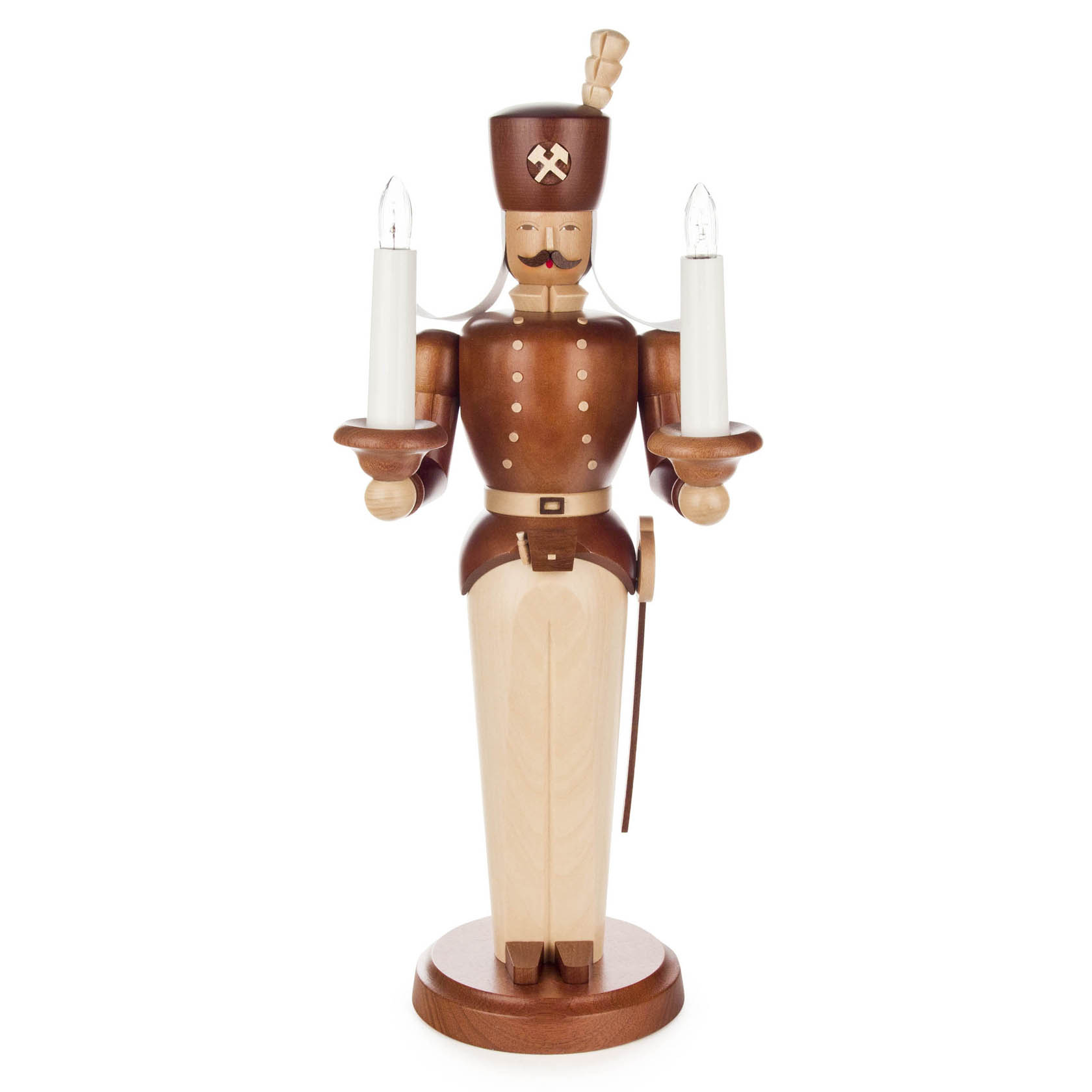 A wooden miner figurine stands holding two lit candles, one in each hand. The figurine features detailed craftsmanship, including a mustache and mining symbols.