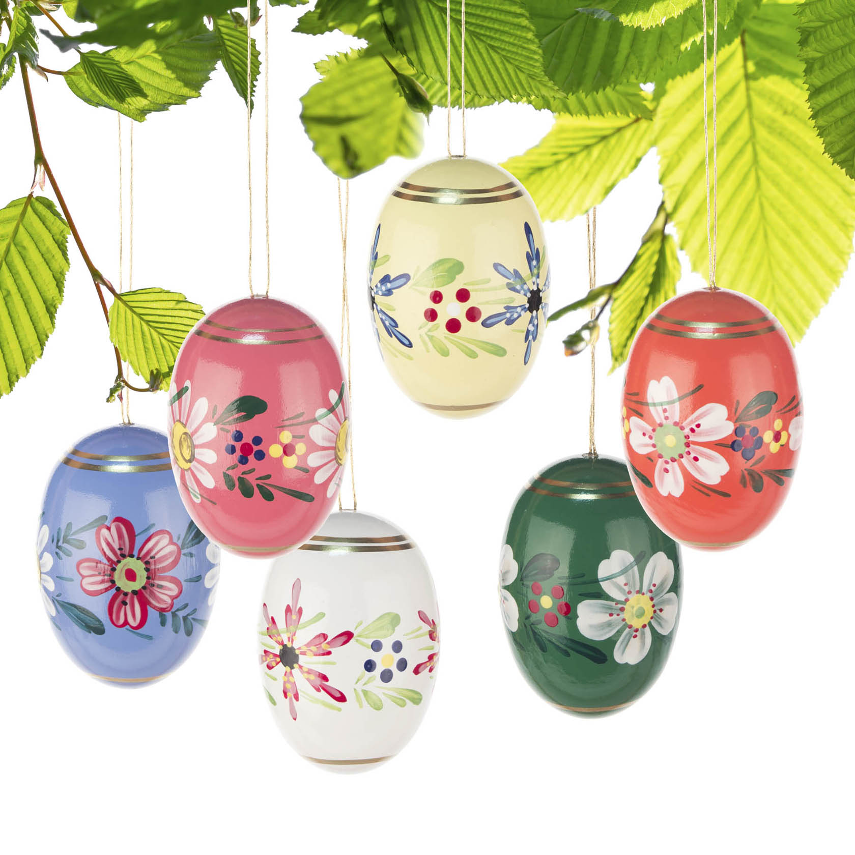 Sechs Ostereier mit handgemalten Blumenmotiven in verschiedenen Farben hängen an einer natürlichen, grünen Aststruktur.