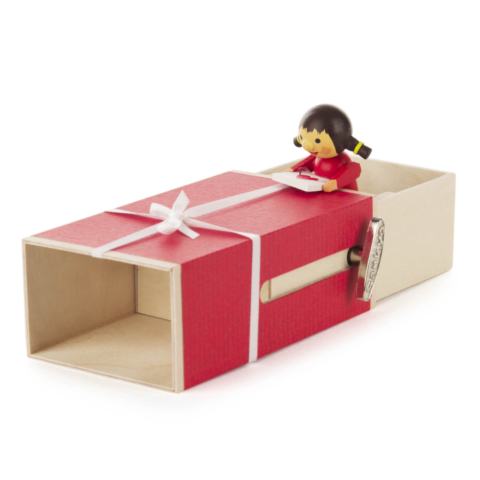 A red 'gift box' music box with a small girl figurine holding a letter on top, and a crank handle labeled 'Canon in D Major'.