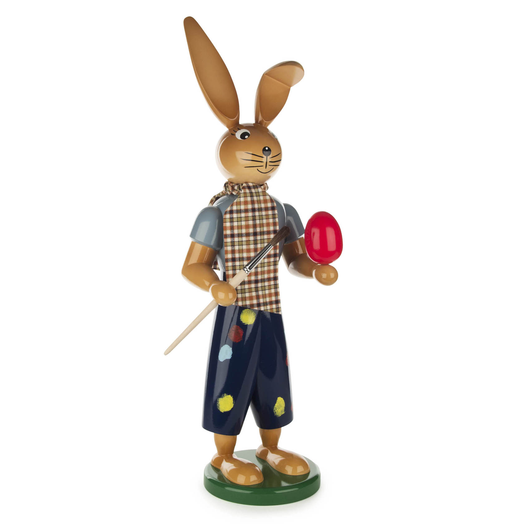 Eine 55 cm hohe Hasenfigur, die ein Pinsel in einer Hand und ein bemaltes rotes Ei in der anderen Hand hält. Der Hase trägt karierte Kleidung und hat lange Ohren. im Dregeno Online Shop günstig kaufen