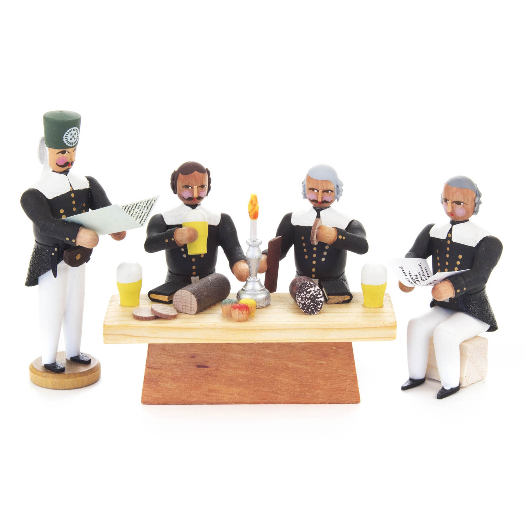Vier Bergleute in traditioneller Tracht sitzen um einen Holztisch mit Essen und Getränken, eine Kerze in der Mitte. Zwei lesen vor. im Dregeno Online Shop günstig kaufen