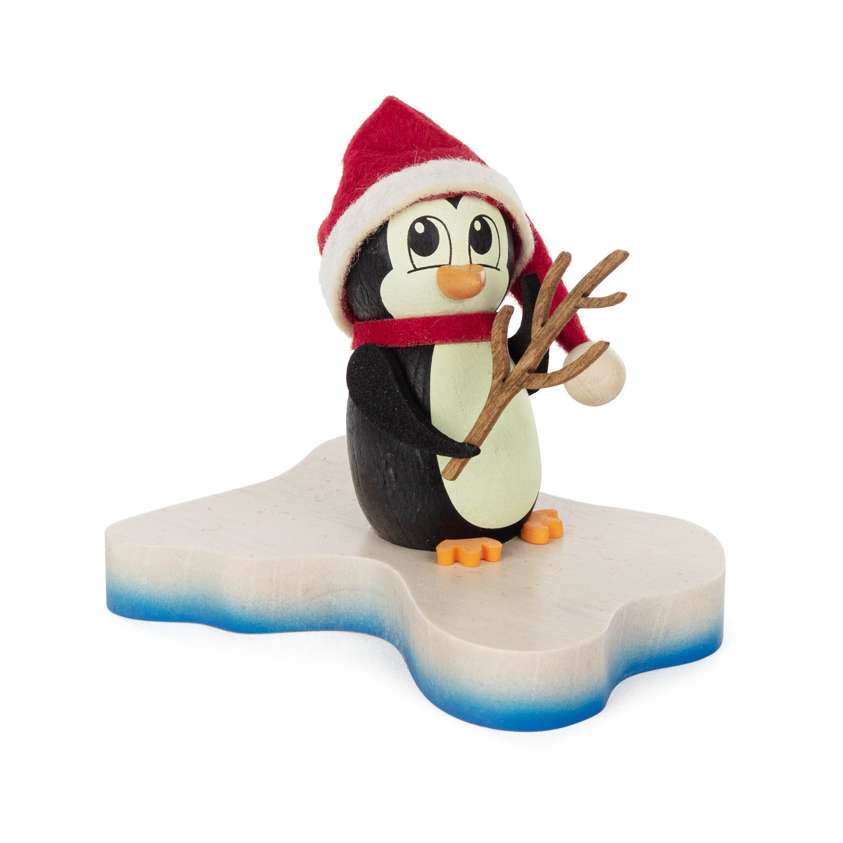 Eine niedliche Pinguinfigur mit Weihnachtsmannmütze und Schal, hält einen kleinen Ast in der Flosse. Die Figur steht auf einer flachen weißen Plattform. im Dregeno Online Shop günstig kaufen
