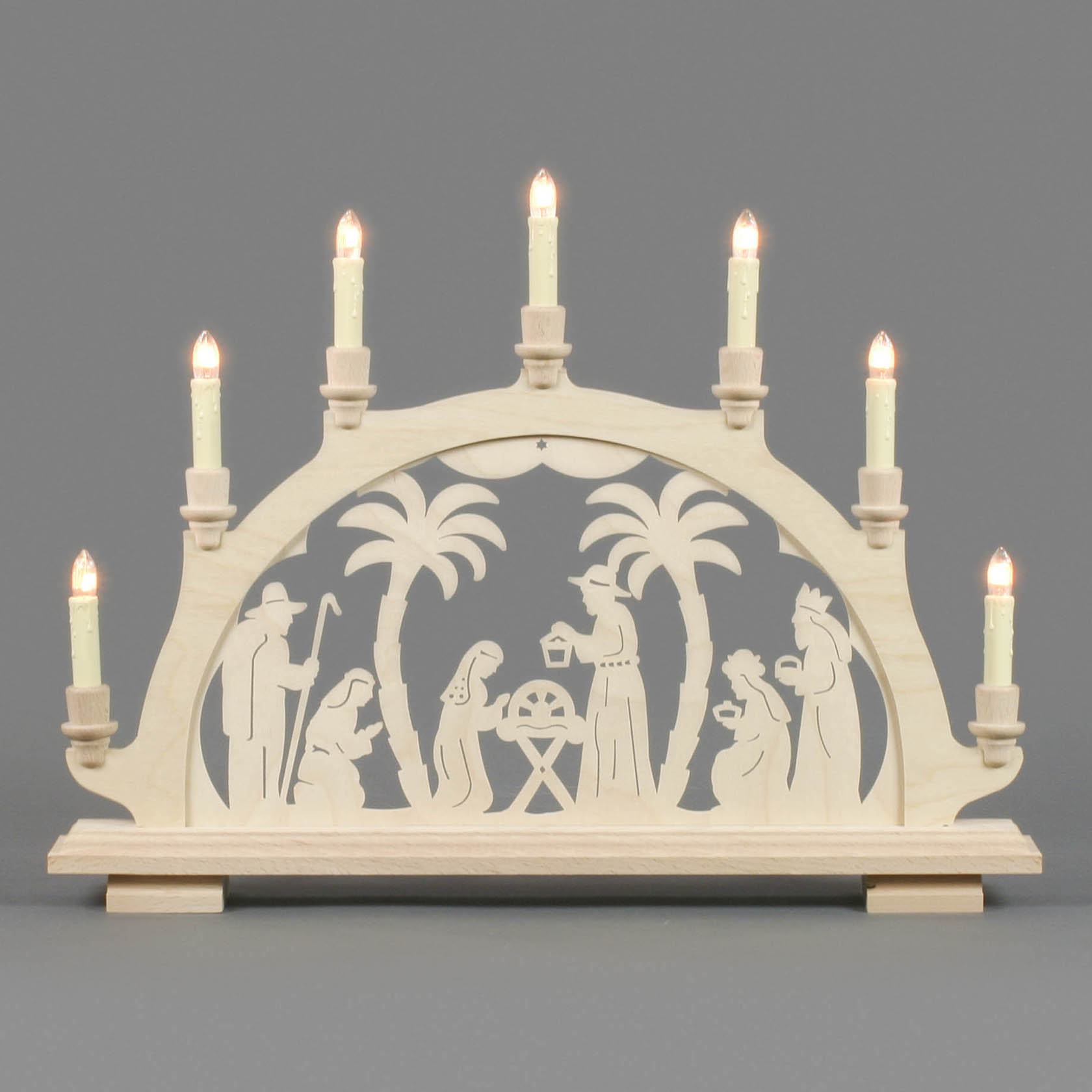 An electrically lit wooden arch with a nativity scene featuring Mary, Joseph, baby Jesus in a manger, shepherds, and three wise men.