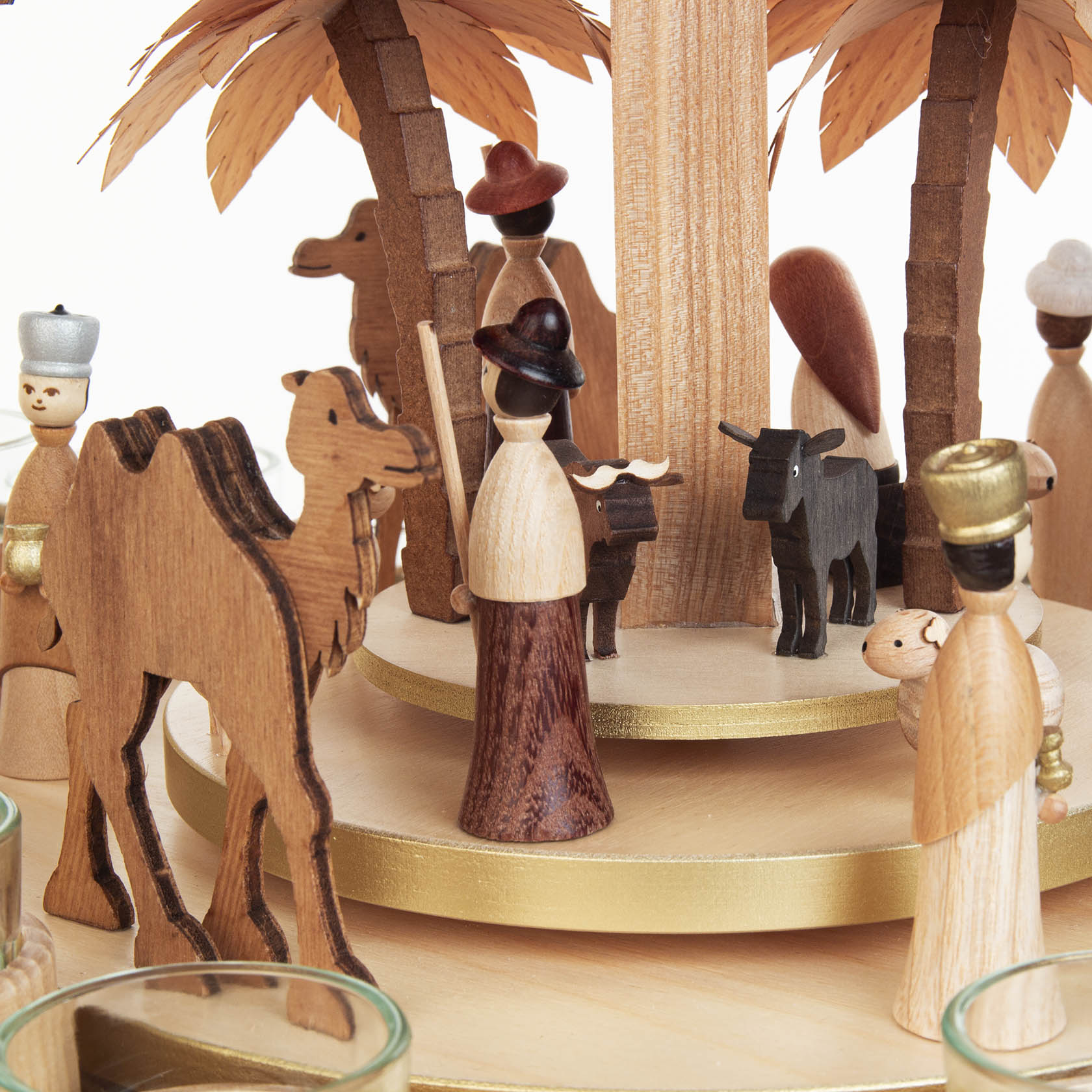 Holzkrippe auf Pyramide mit Figuren der Heiligen Familie, Tieren und Weisen, dekoriert mit zwei Kerzentellern und Flügelrädern.