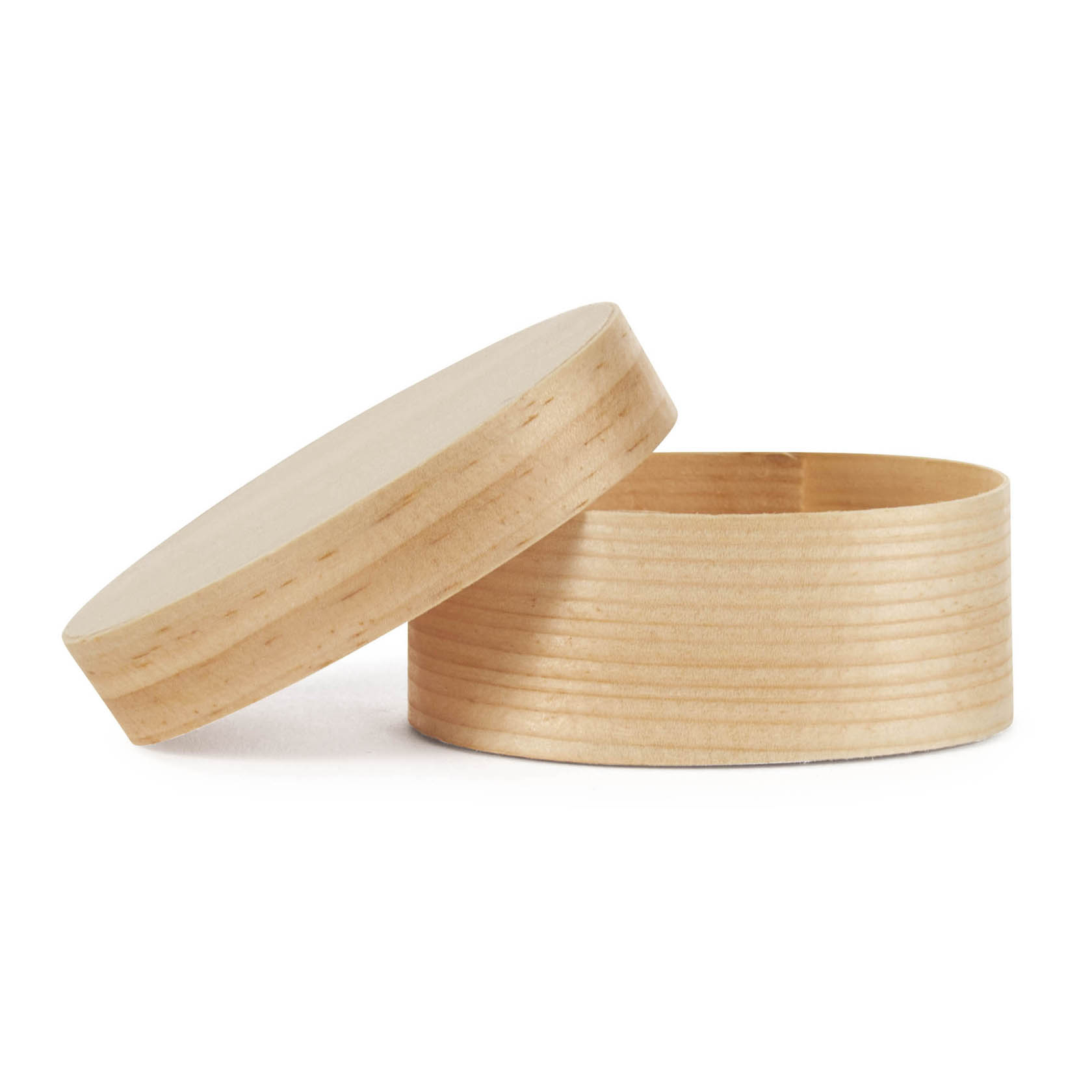 Eine ovale Spanschachtel aus hellem Holz mit abgenommenem Deckel, die senkrecht auf der Seite liegt.