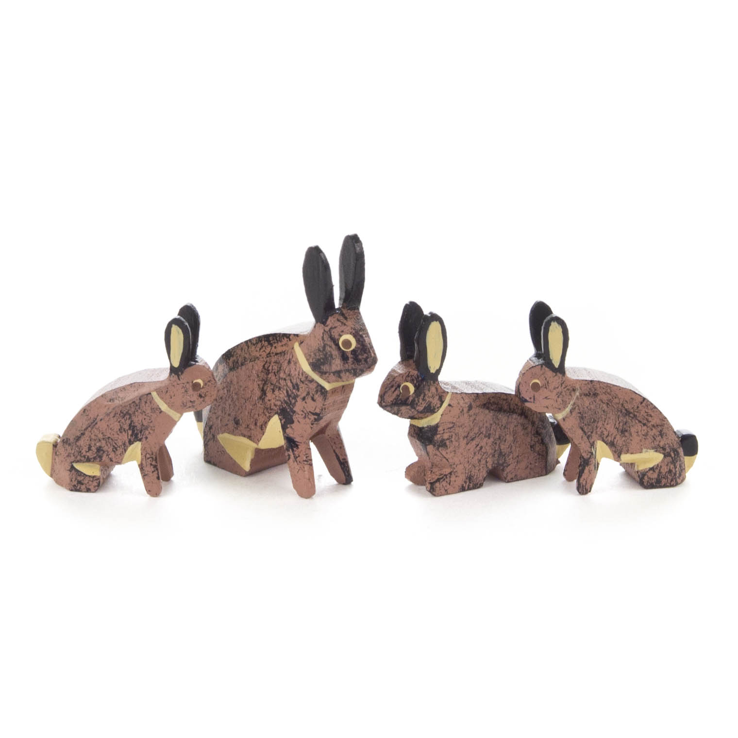Vier hölzerne Hasenfiguren in unterschiedlichen Größen, naturfarben bemalt mit schwarzen Ohren und Details, stehen nebeneinander.