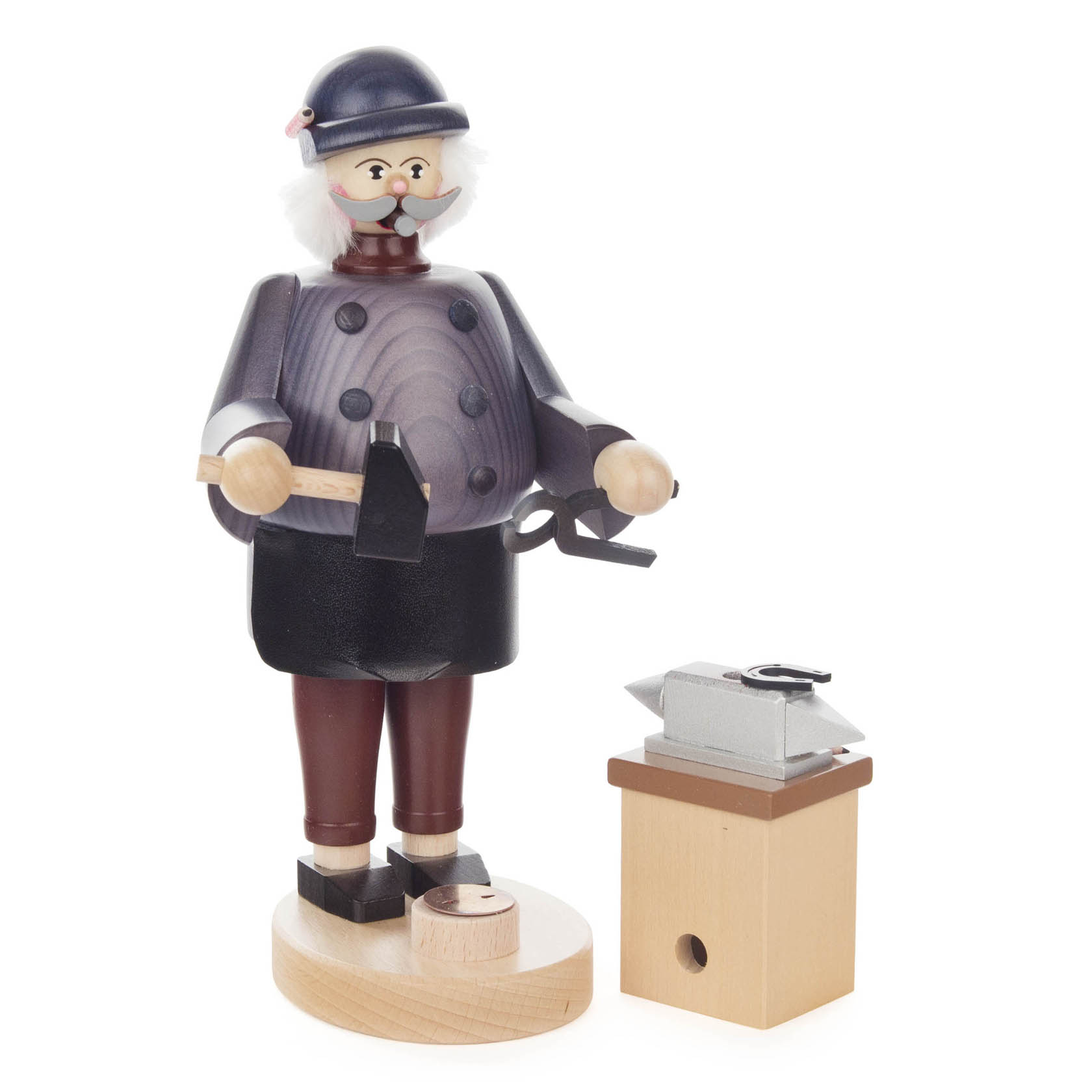 Holzfigur eines Räuchermanns in Form eines Schmieds. Er trägt einen blauen Helm, hält einen Hammer und eine Zange. Neben ihm steht ein Amboss auf einem Holzblock.