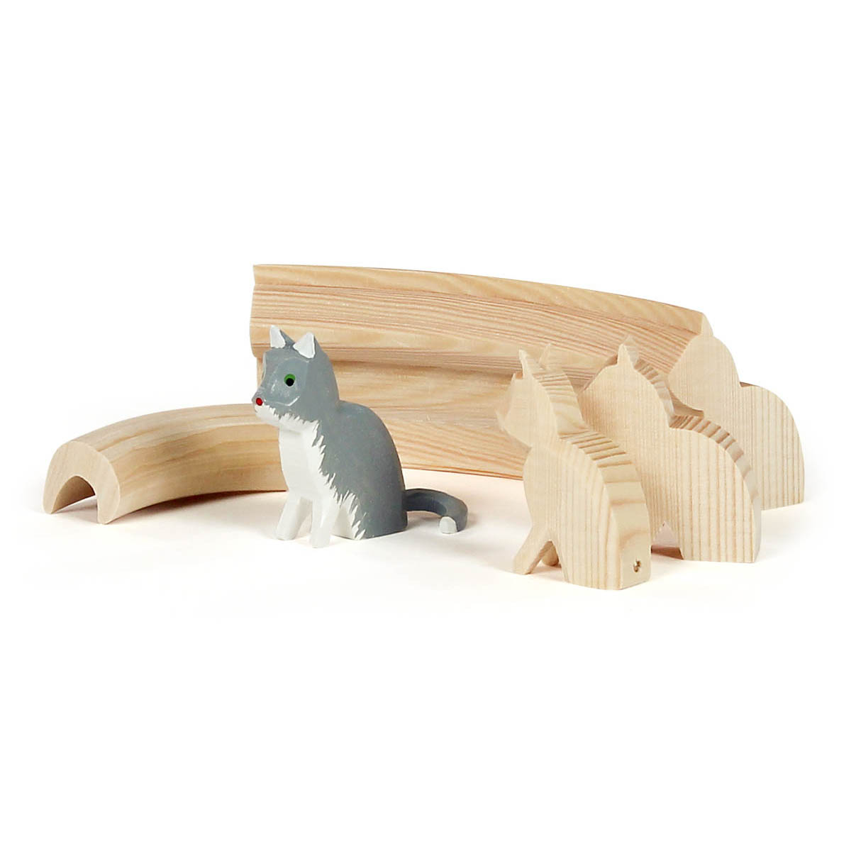 Fünfteiliger Schnitzrohling eines Reifentiers in Form einer Katze. Vordergrund zeigt bemalte Holzkatze, Hintergrund zeigt vier Rohlinge unterschiedlicher Entwicklungsstufen. im Dregeno Online Shop günstig kaufen