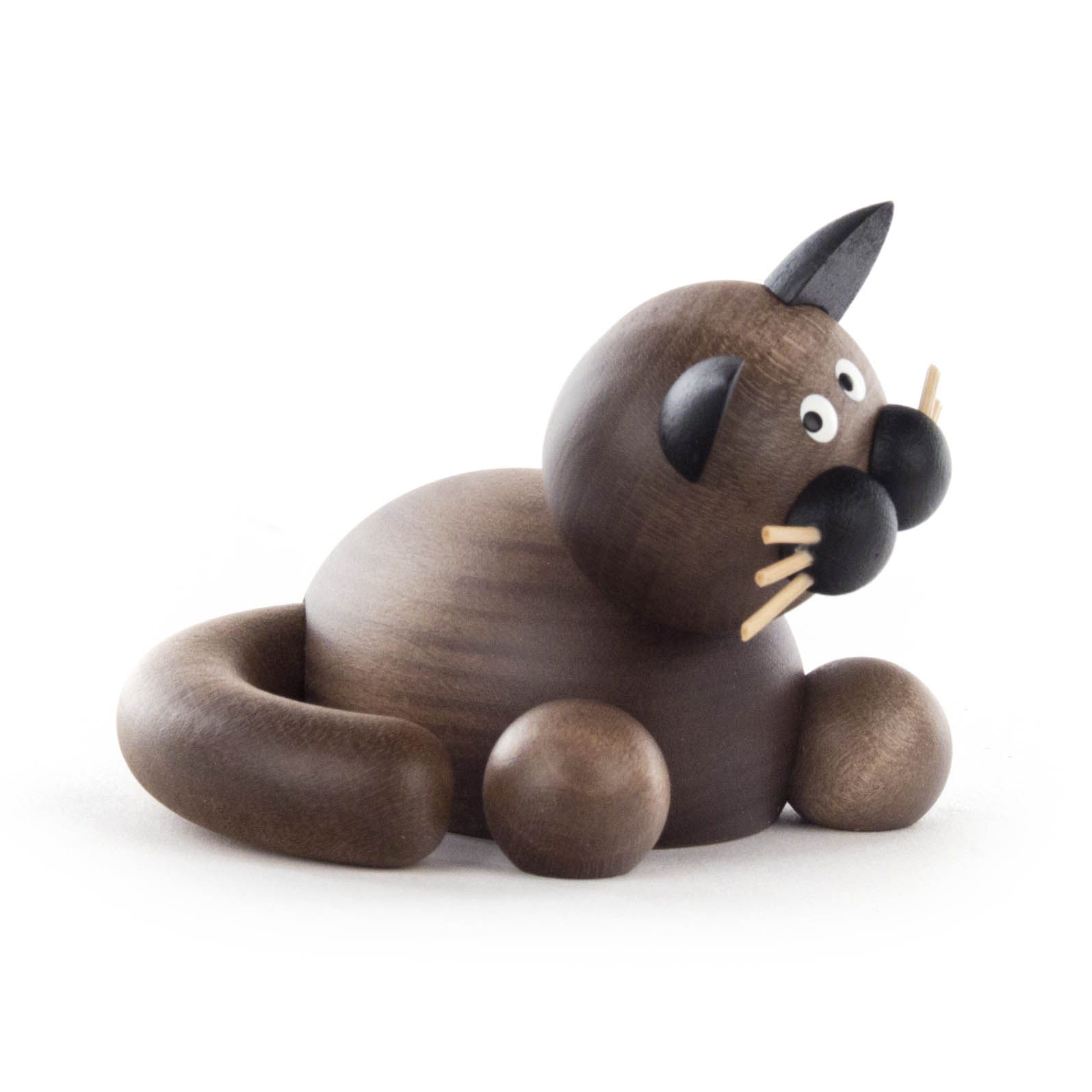 Holzfigur einer grauen Katze mit schwarz betonter Nase und Schnurrhaaren, die auf dem Boden sitzend abgebildet ist.