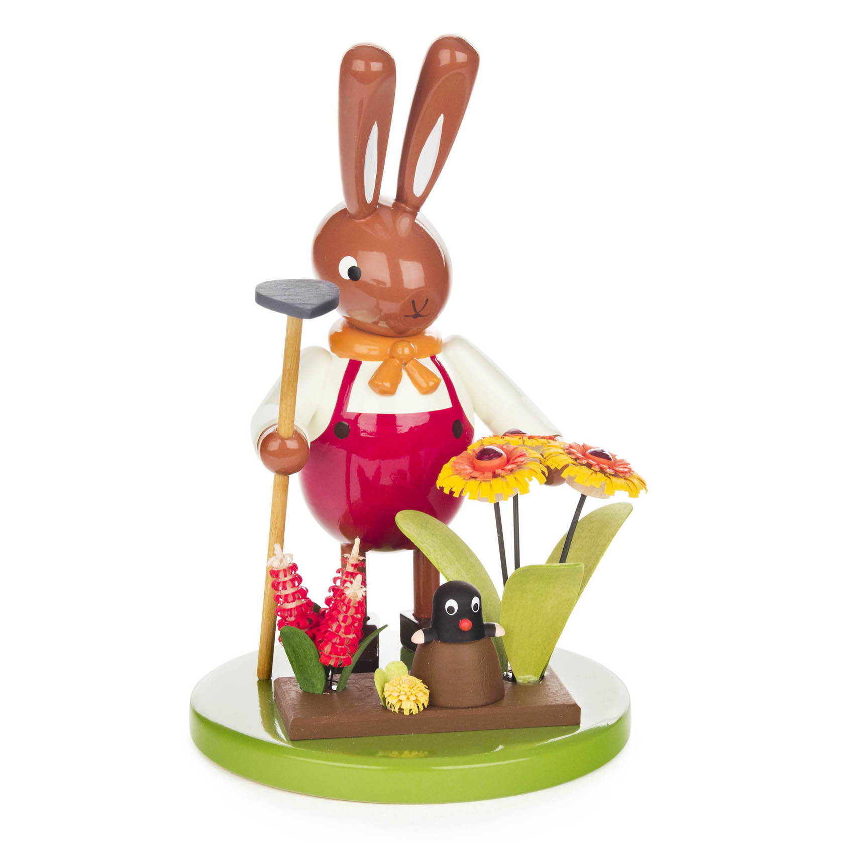 Holzfigur eines Hasen mit orangefarbener Schleife und roter Latzhose, der eine Hacke hält. Daneben ein Maulwurf und bunte Blumen auf einer grünen Plattform. im Dregeno Online Shop günstig kaufen