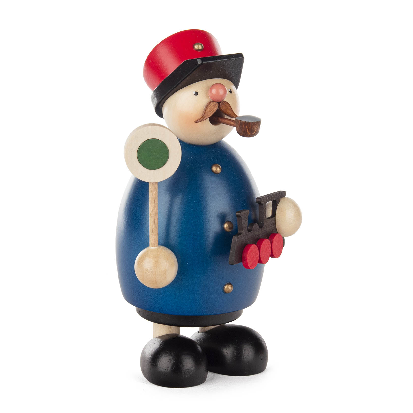 Holzfigur eines Eisenbahners in blauer Uniform mit roter Mütze, pfeiferauchend, hält ein Zug-Signal und modellhafte Dampflok.