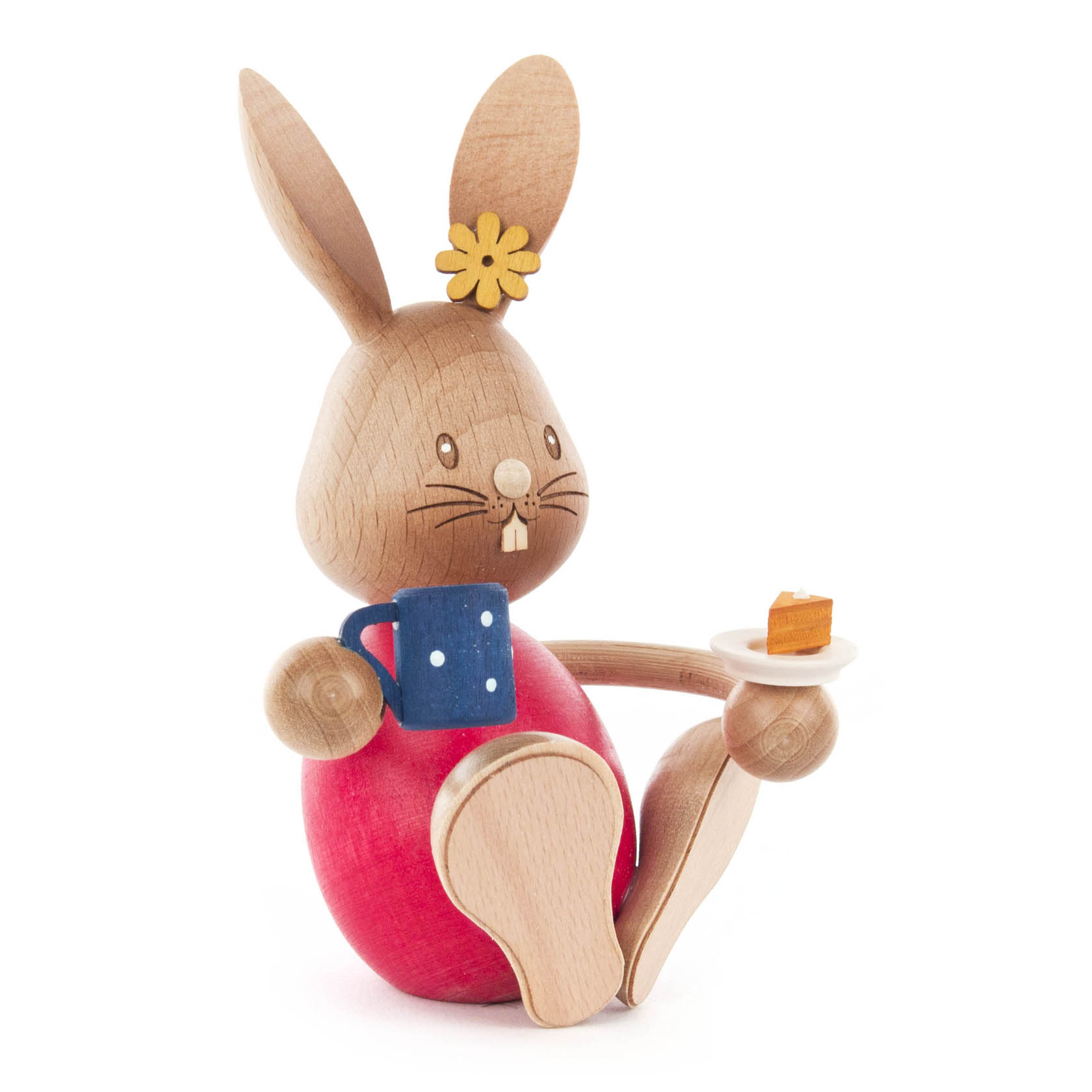 Holzhase Stupsi hält eine blaue Kaffeetasse in der rechten Hand und ein Stück Kuchen auf einem Teller in der linken Hand. im Dregeno Online Shop günstig kaufen