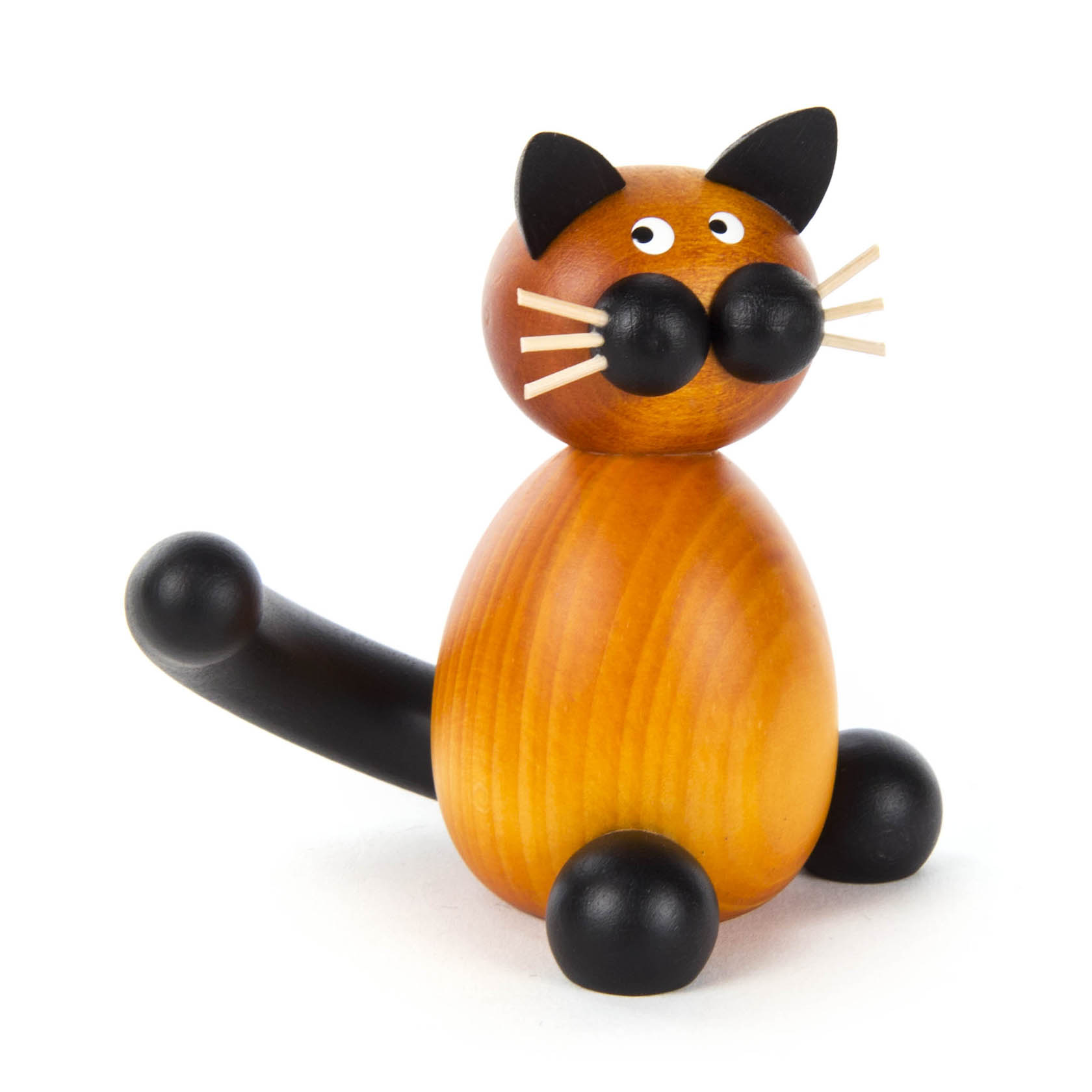 Eine Holzfigur einer Katze namens Bommel, sitzend, mit orangefarbenem Körper, schwarzen Ohren, Schwanz, Pfoten und Schnurrhaaren. im Dregeno Online Shop günstig kaufen