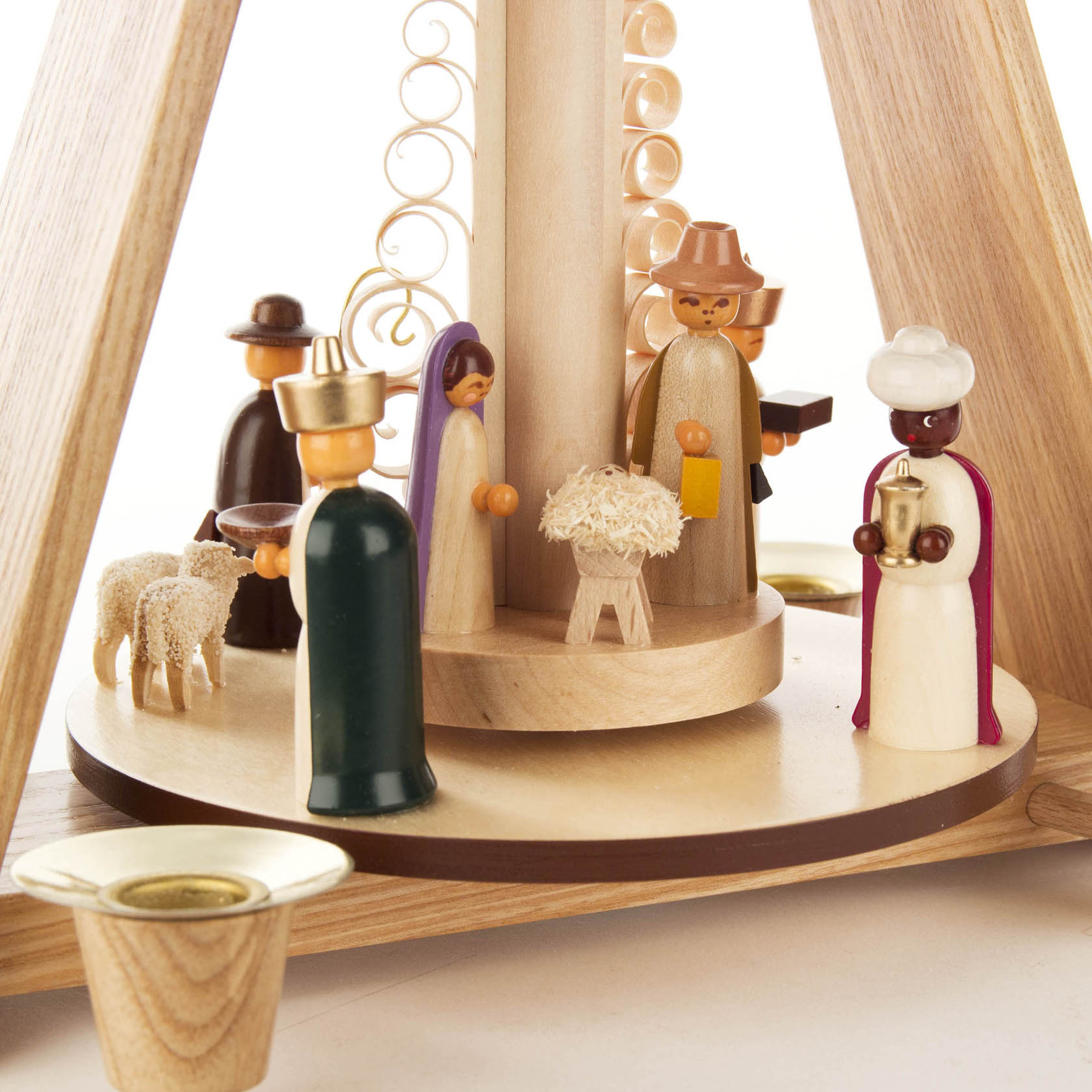 Weihnachtspyramide mit sechs farbigen Holzfiguren, die die Geburt Christi darstellen, darunter Maria, Josef, die Heiligen Drei Könige und zwei Schafe.