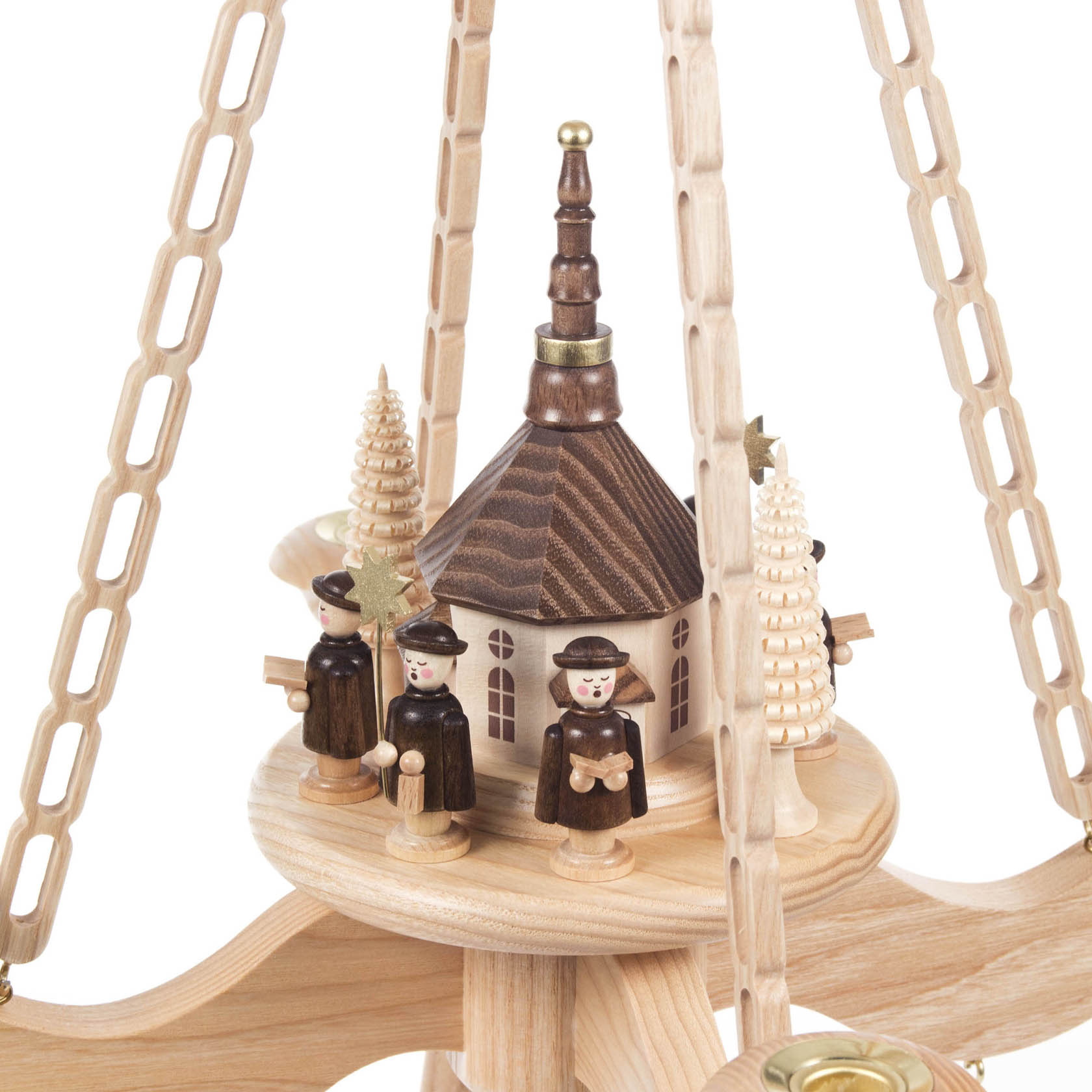 Detail einer Holz-Hängepyramide mit einer Seiffener Kirche in der Mitte, umgeben von drei traditionellen Kurrende-Sängern und zwei geschnitzten Bäumen.