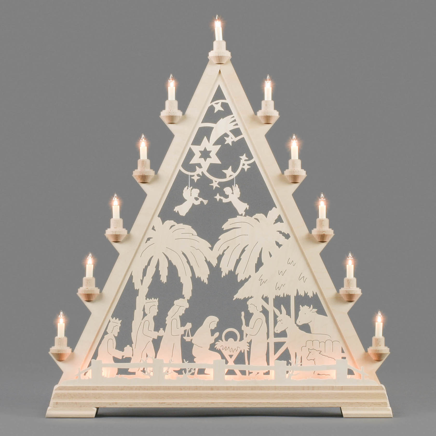 Holzdreieck mit zehn Lichtern zeigt in der Mitte eine Szene der Geburt Christi mit Maria, Josef und dem Jesuskind in einer Krippe, flankiert von Palmen.