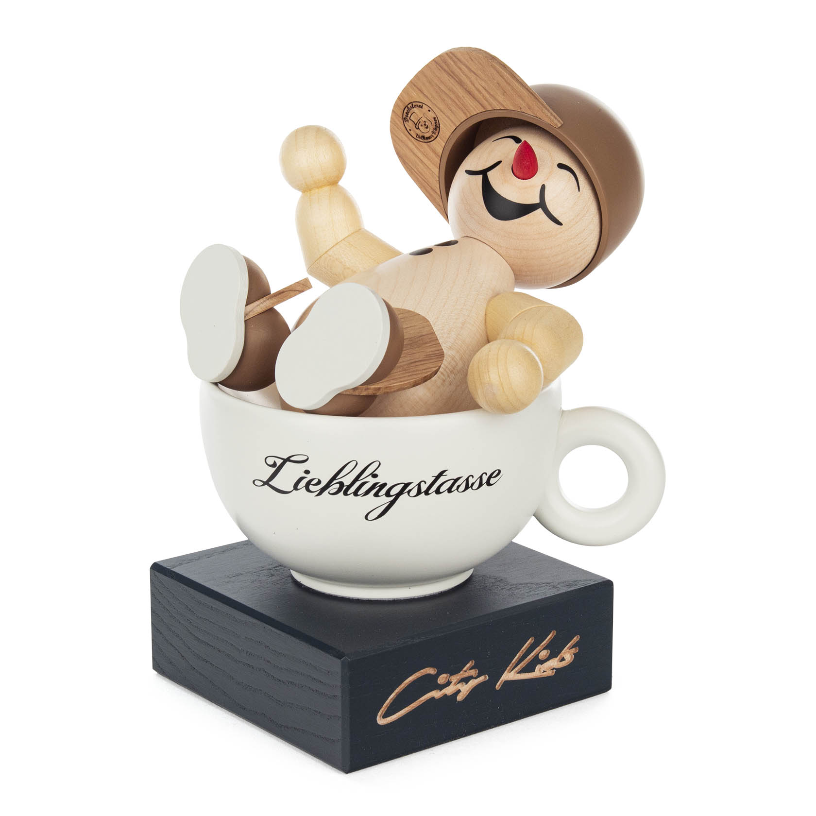 Holzfigur eines fröhlich lachenden Kindes mit brauner Kappe und roter Nase, die in einer weißen Tasse mit Aufschrift 'Lieblingstasse' sitzt. im Dregeno Online Shop günstig kaufen