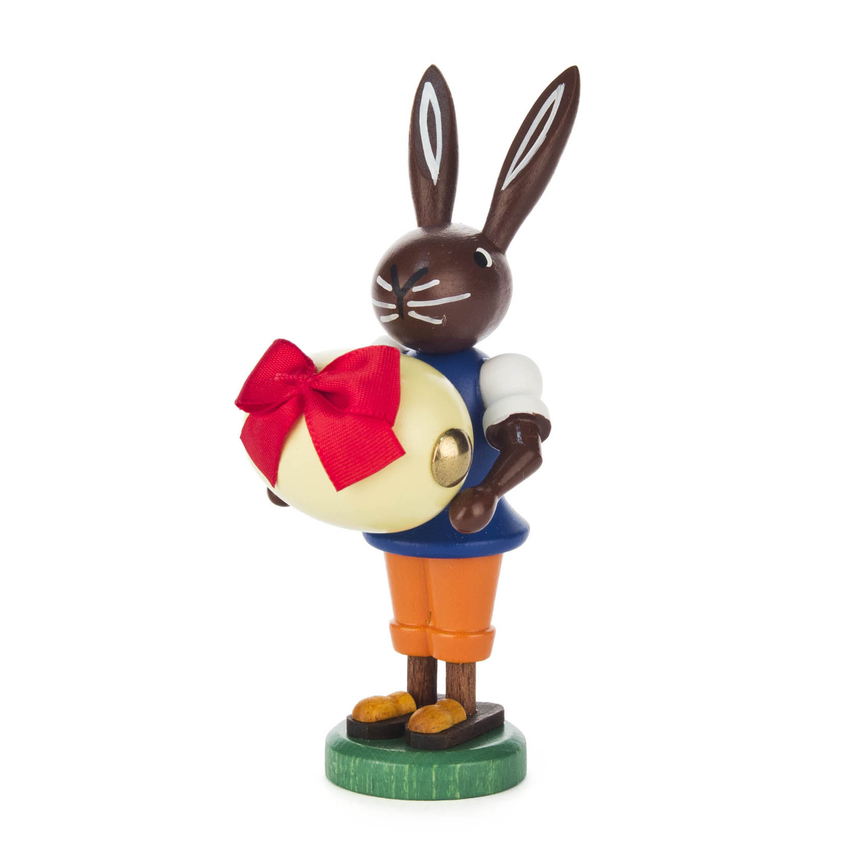 Holzfigur eines stehenden Osterhasen in blauer Jacke und oranger Hose, der ein großes Ei mit roter Schleife hält. im Dregeno Online Shop günstig kaufen