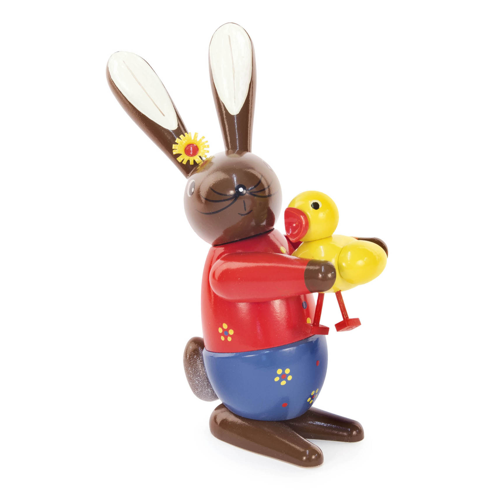 Eine lächelnde Osterhasenfigur mit braunem Fell und einer gelben Blume am Ohr, hält ein gelbes Küken in den Armen. Die Figur trägt einen roten Pullover. im Dregeno Online Shop günstig kaufen