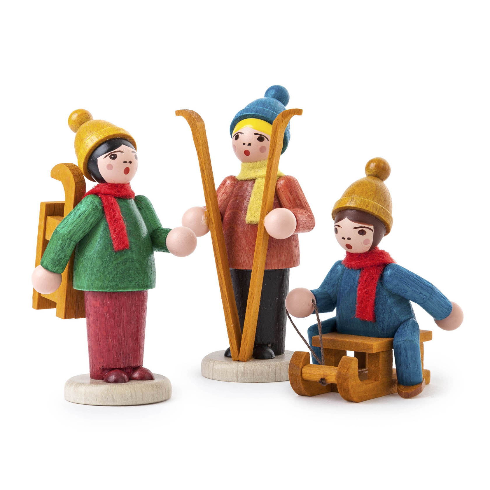 Drei farbig lasierte Wintersportfiguren aus Holz: ein Skifahrer, ein Schneeschuhwanderer und ein Rodler, alle in bunten Winterkleidern mit Mützen und Schals. im Dregeno Online Shop günstig kaufen