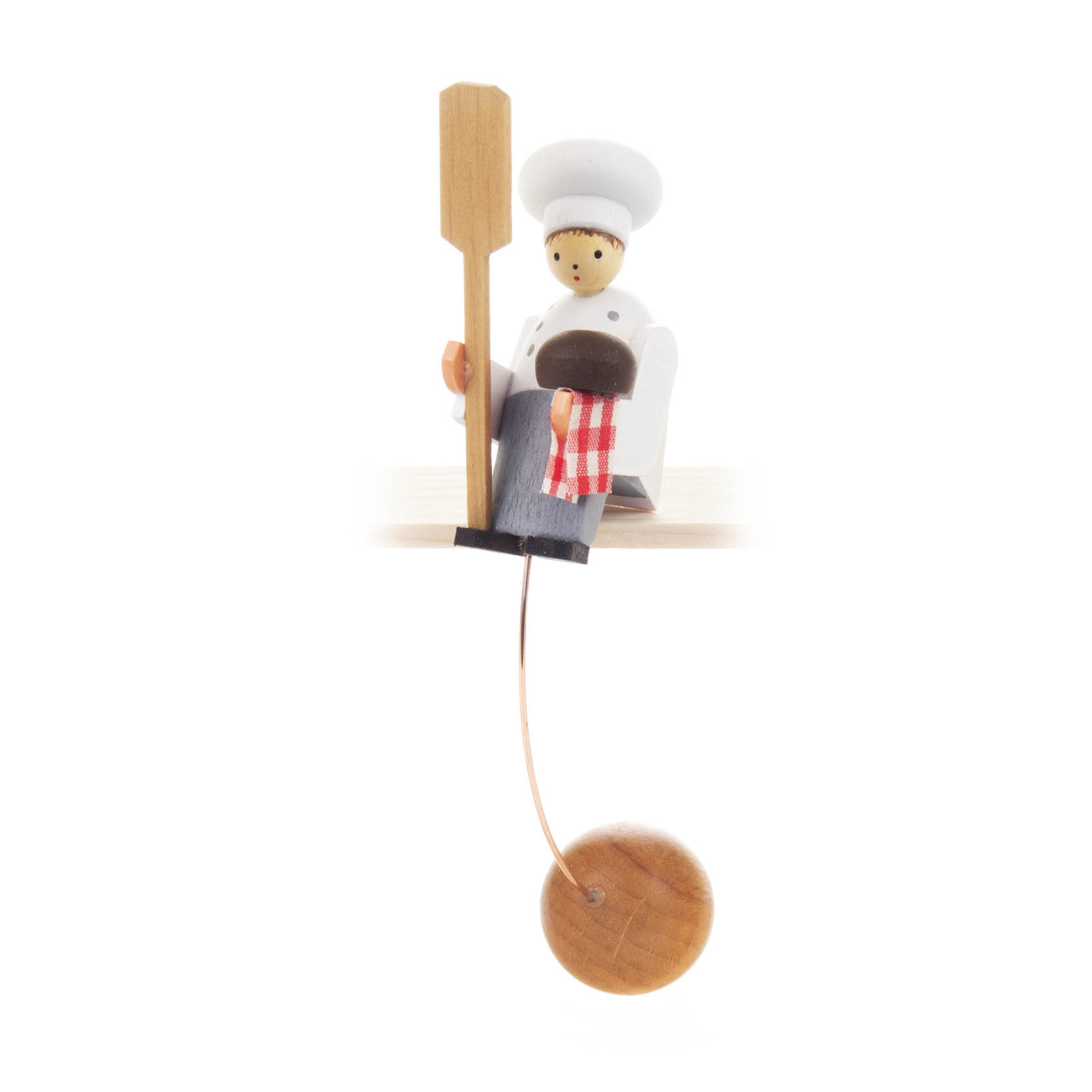 Holzfigur eines Bäckers mit weißer Kleidung und Bäckermütze. Er hält eine Bäckerschaufel und sitzt auf einem Brett mit einem rot-weiß-karierten Tuch. im Dregeno Online Shop günstig kaufen