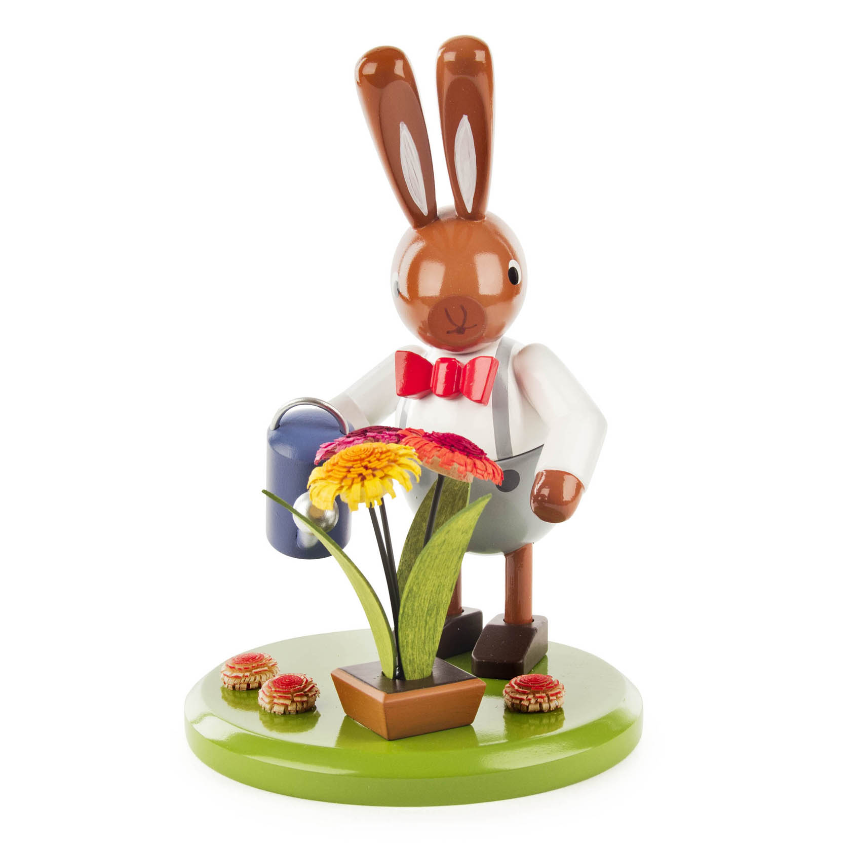 Figur eines Hasen im weißen Hemd mit roter Fliege und grauer Hose gießt mit einer blauen Gießkanne eine Topfpflanze mit bunten Blumen. im Dregeno Online Shop günstig kaufen
