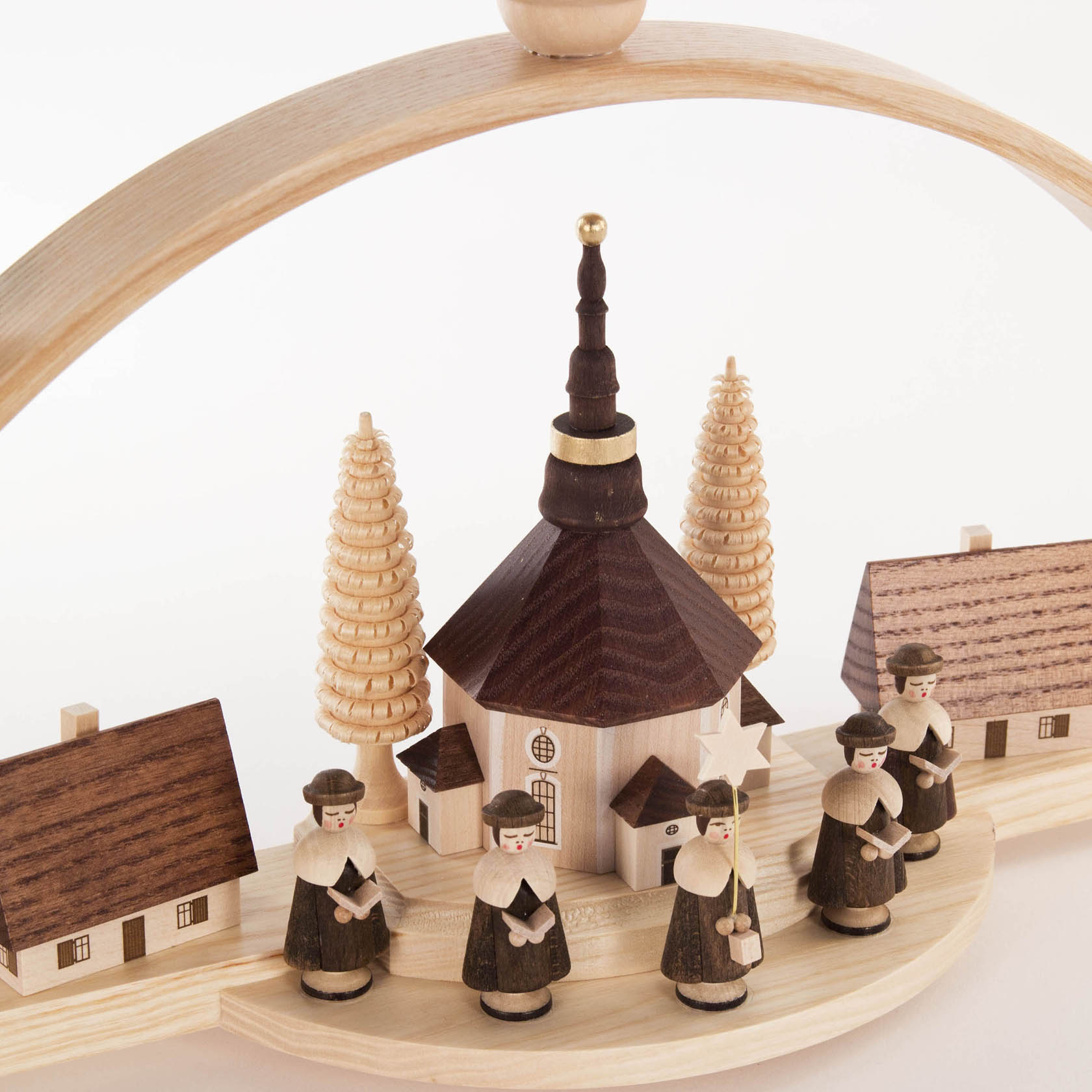 Holzschwibbogen mit detailreichem Seiffener Dorf-Motiv, zeigt Kurrende-Sängerfiguren vor Kirche, umrahmt von zwei Häusern und Tannenbäumen.