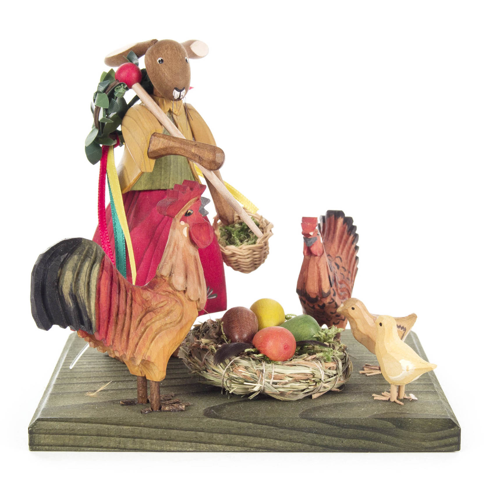 Holzfigur eines Hasenmädchens mit buntem Kleid, das einen Korb mit grünem Gras hält, umgeben von bemalten Holz-Hühnern und einem Nest mit Eiern. im Dregeno Online Shop günstig kaufen