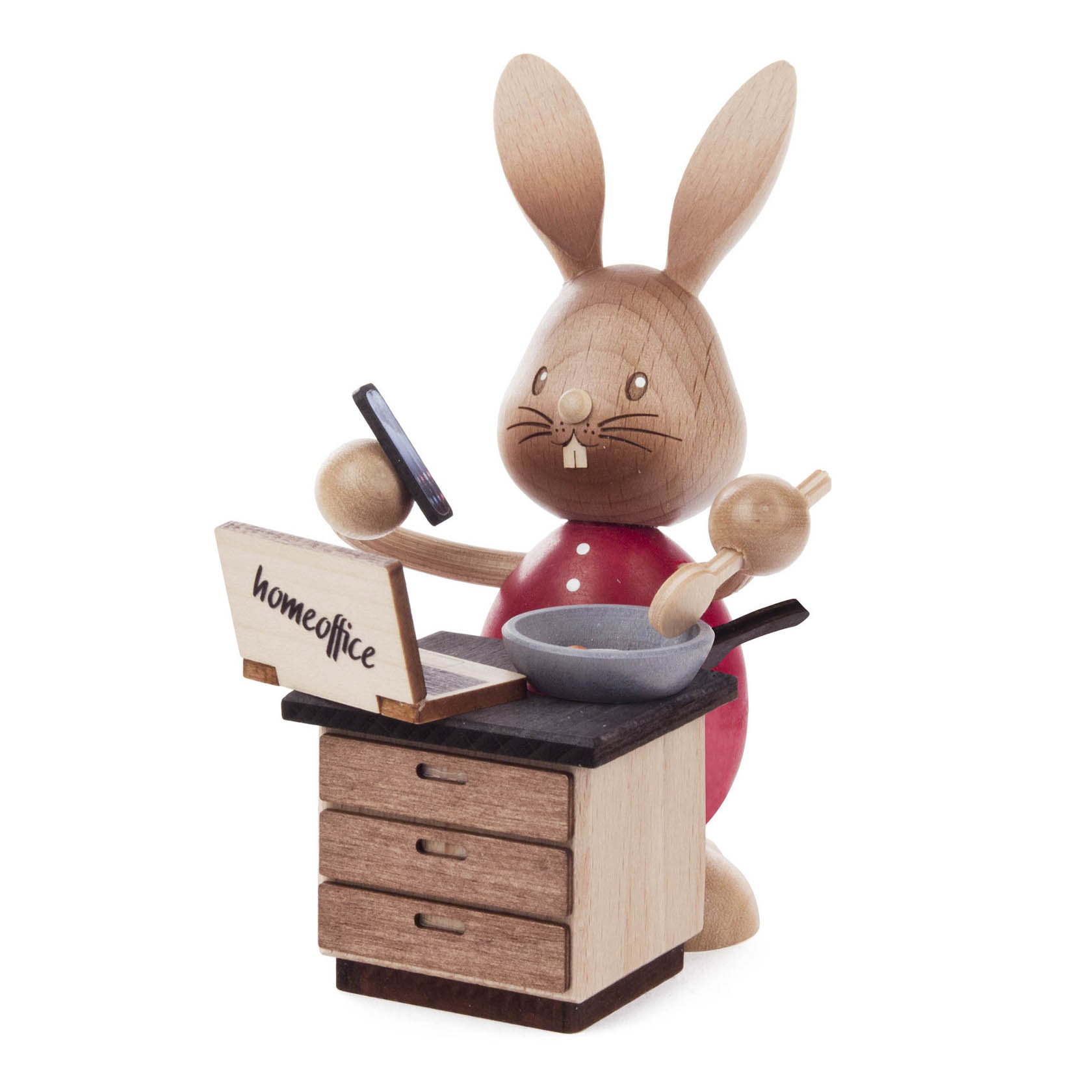 Holzfigur eines Hasen namens Stupsi, der in einem Homeoffice arbeitet. Er hält ein Smartphone in der rechten Hand und eine Bratpfanne in der linken. im Dregeno Online Shop günstig kaufen