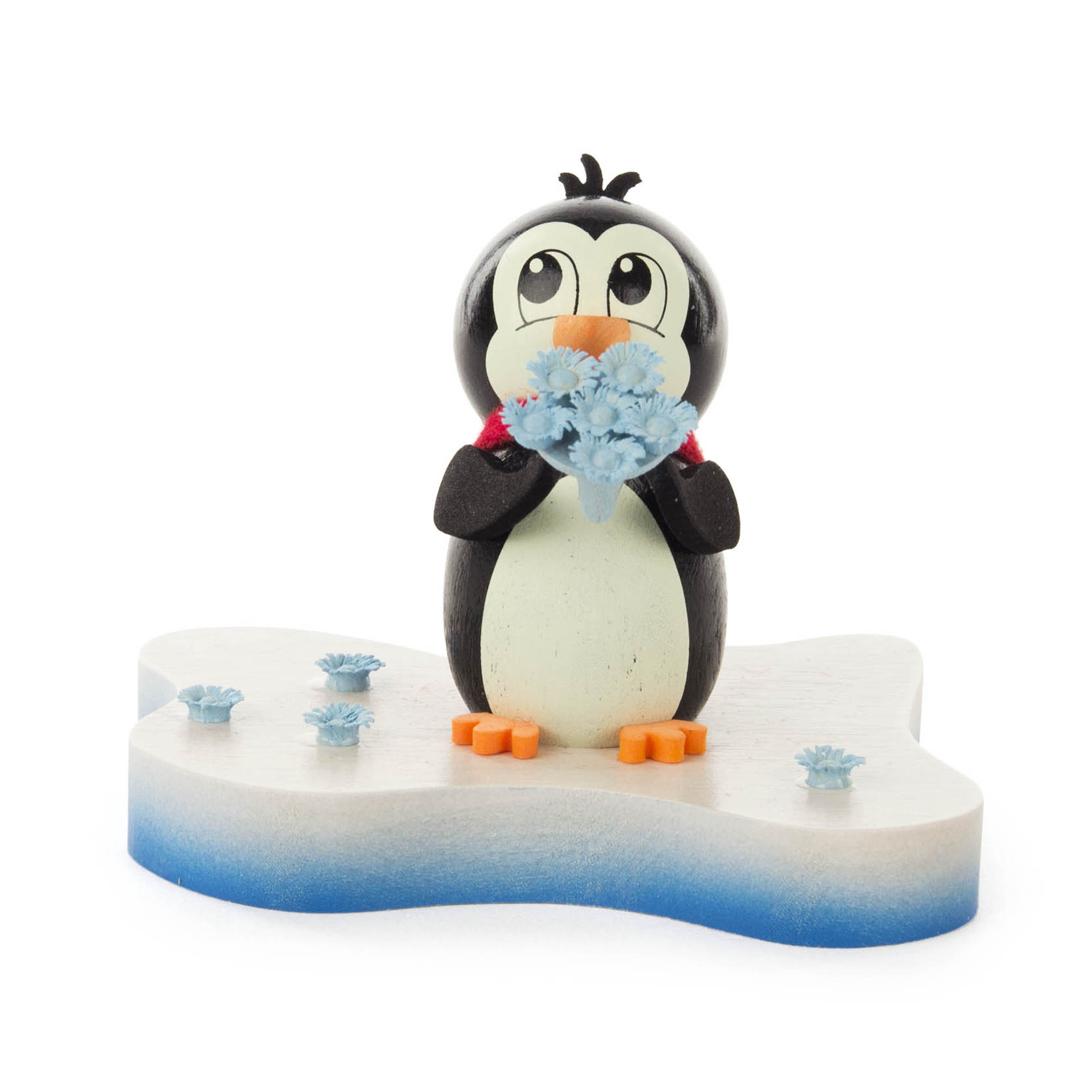 Eine Holzfigur eines Pinguins, der einen Strauß blauer Blumen hält. Der Pinguin steht auf einer eisförmigen Basis mit weiteren blauen Blumen darauf.