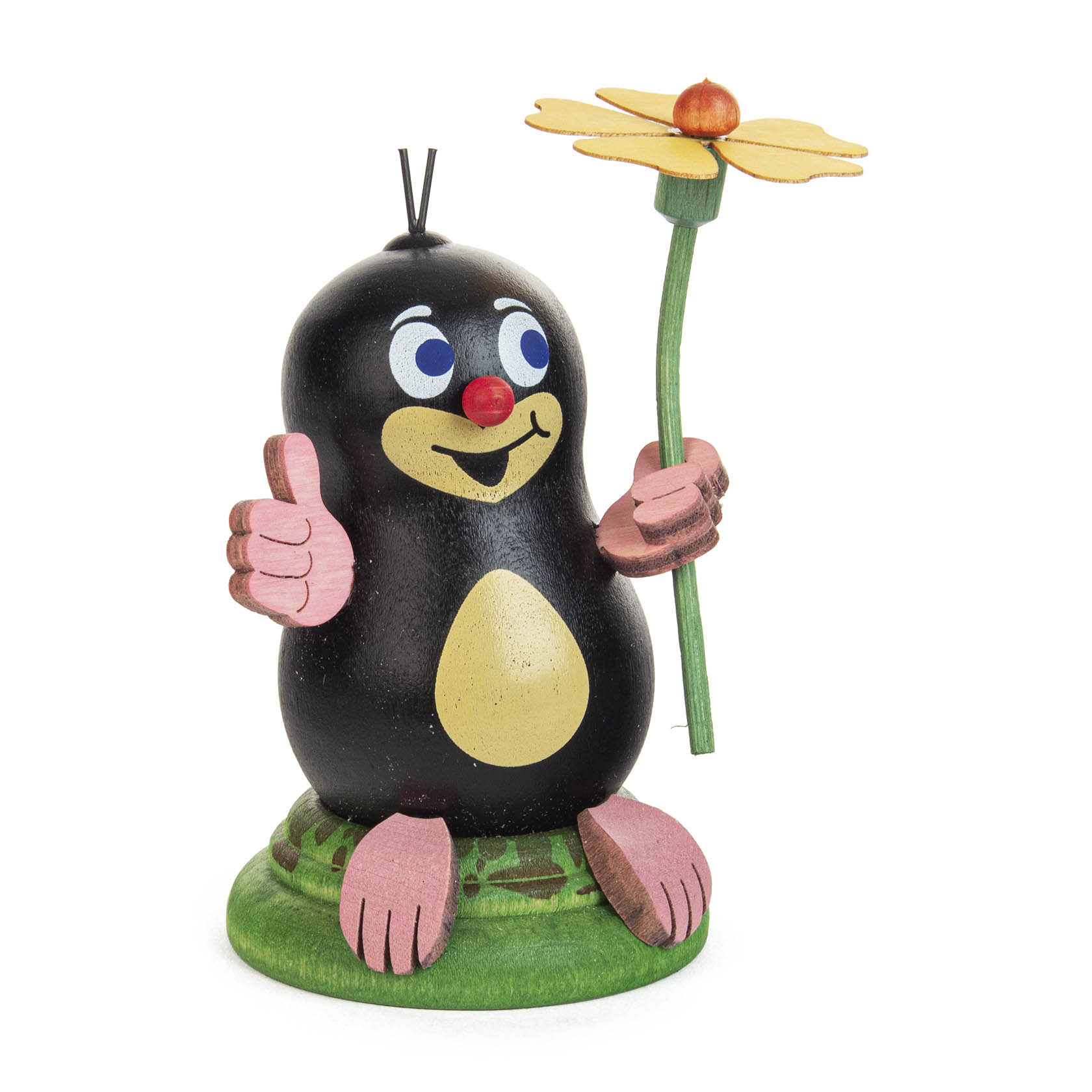 A cute wooden mole figure named Herbert, with a black body, beige belly, red nose, and pink paws, holding a yellow flower and giving a thumbs-up. im Dregeno Online Shop günstig kaufen