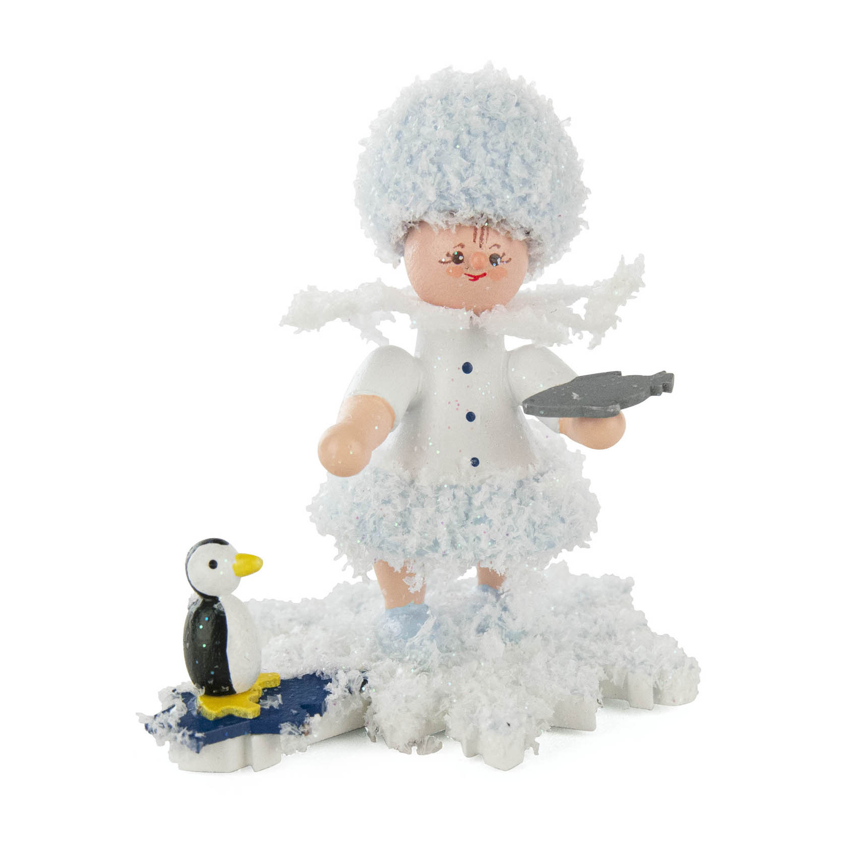 Ein figürliches Schneeflöckchen in weißen Winterkleidern mit flauschigem Hut hält ein kleines silbernes Objekt in der Hand, steht auf einem weißen Sockel mit einem kleinen Pinguin. im Dregeno Online Shop günstig kaufen