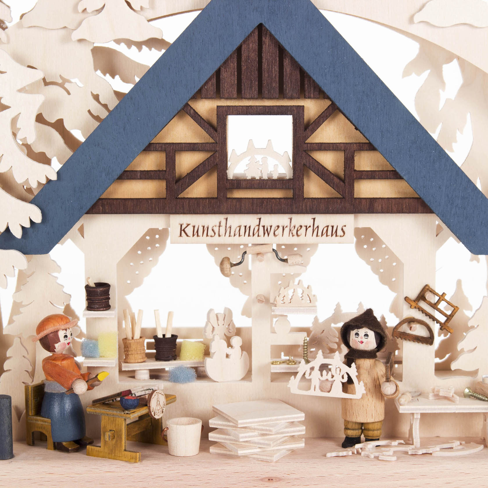Schwibbogen mit dem Thema 'Kunsthandwerkerhaus', zeigt zwei Figuren bei der Holzarbeit, einschließlich Schnitzerei und Malerei, mit indirekter Beleuchtung.