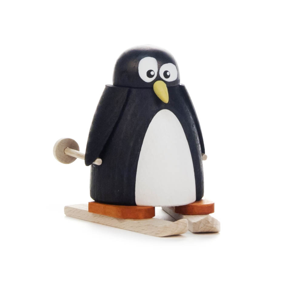 Holzfigur eines Pinguins mit Skiern und Stöcken, der auf Skiern steht. Der Pinguin hat große Augen und trägt orangefarbene Skischuhe. im Dregeno Online Shop günstig kaufen