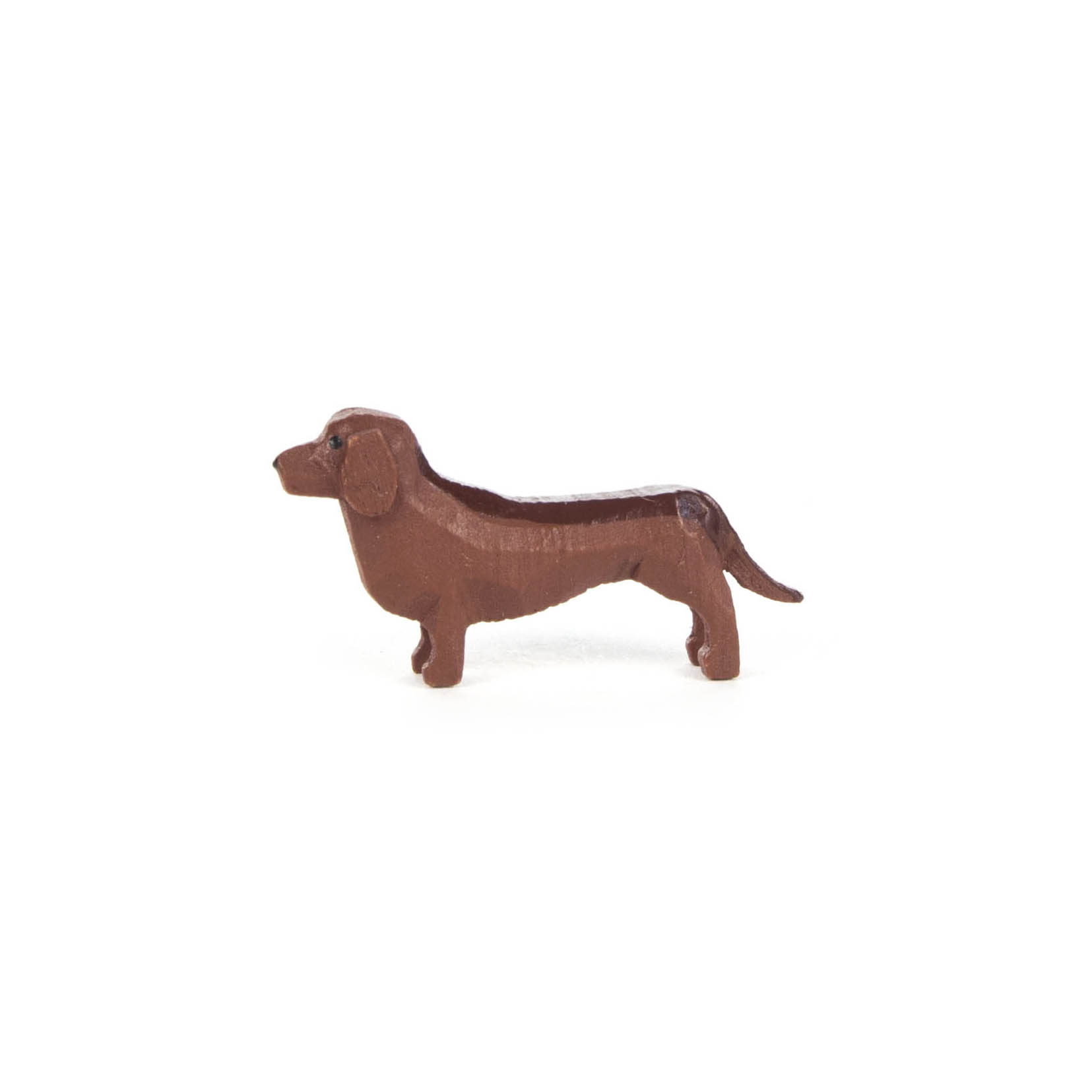 Eine kleine braune Spielzeugfigur in Form eines Dachshunds mit langen Ohren und kurzem Körper, seitlich von links abgebildet. im Dregeno Online Shop günstig kaufen