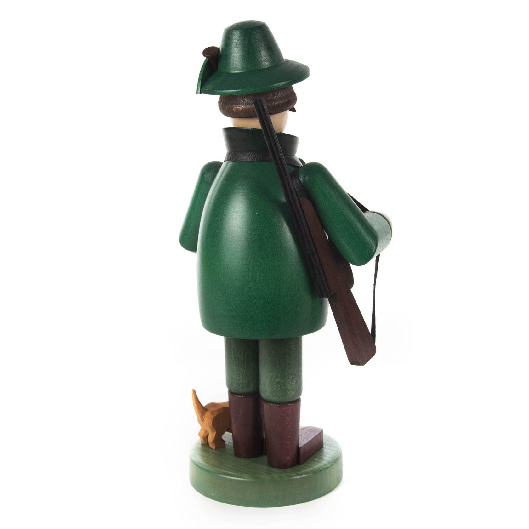 Holzfigur eines Försters mit grünem Mantel und Hut, hält ein Gewehr in der Hand. Ein kleiner Hund steht neben ihm.