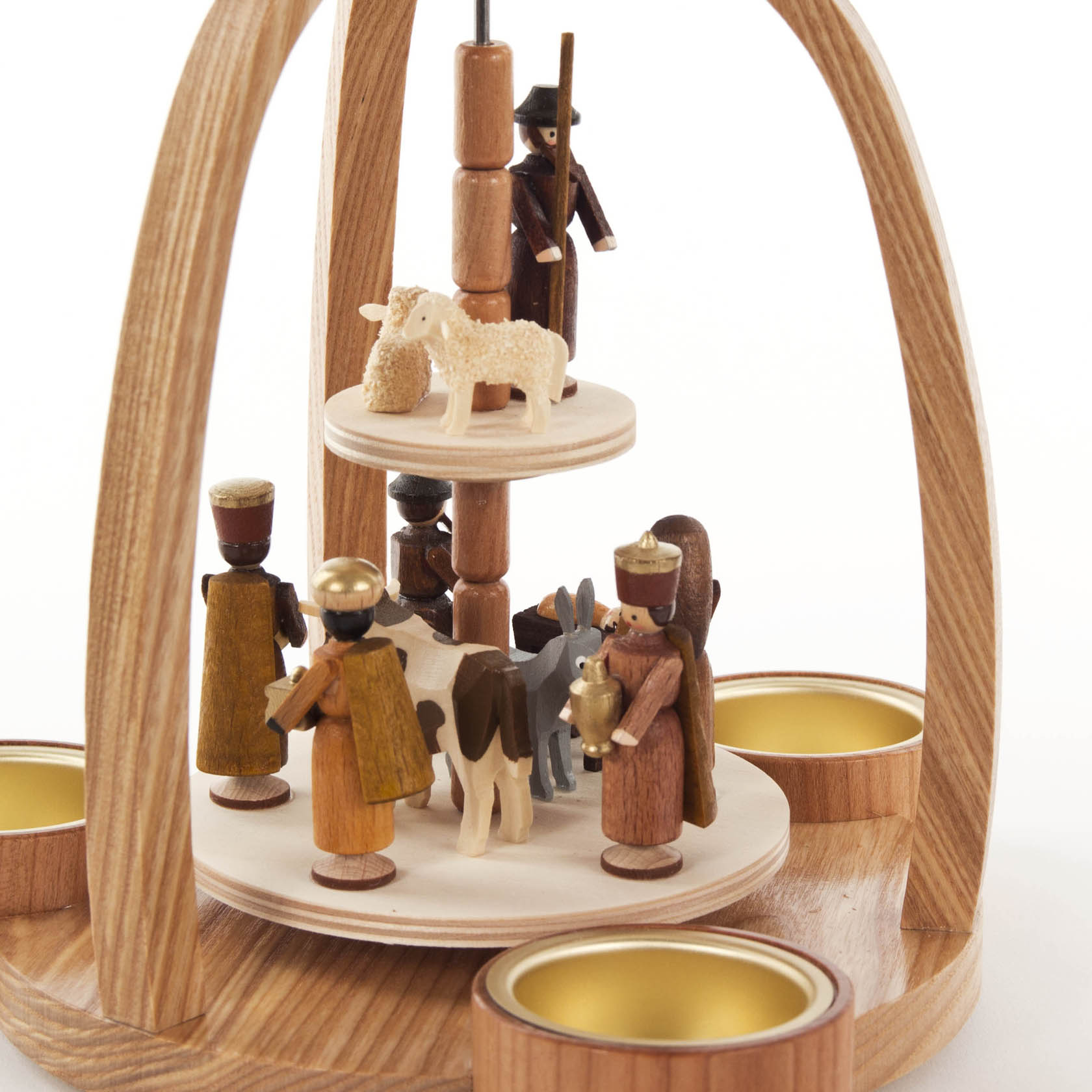 Holzpyramide mit Szenen der Geburt Christi, darunter die Heiligen Drei Könige, Josef, Maria mit Jesuskind, Ochs, Esel und ein Hirte mit Schaf. Umgeben von Teelichthaltern.