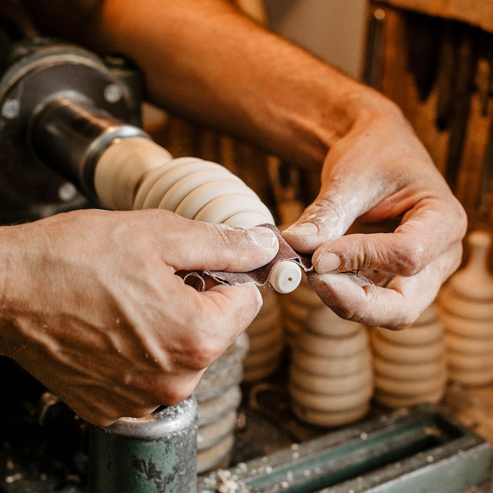 Handwerker glättet auf einer Drehmaschine ein Holzstück für ein handgefertigtes Bienenstockmodell mit Räucherfunktion.