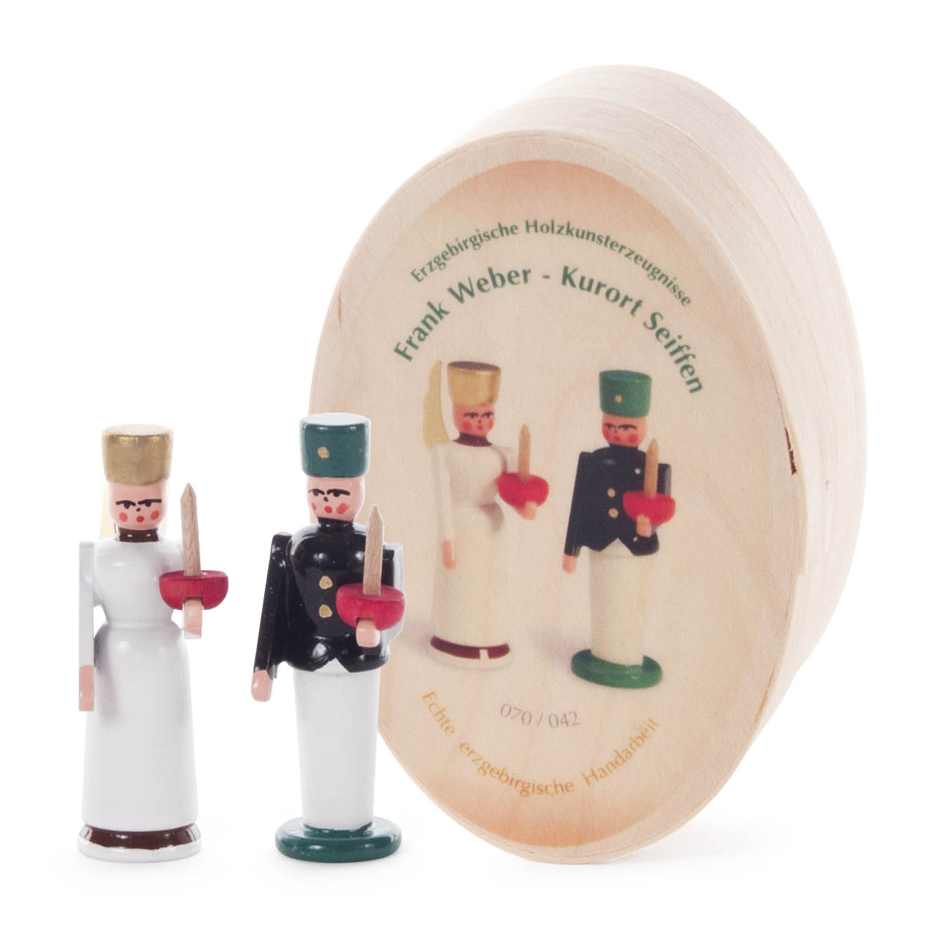 Zwei Holzfiguren, ein Bergmann in Uniform mit Lampe und ein Engel in weißem Kleid, stehen vor einer ovalen Spandose mit Aufschrift 'Frank Weber - Kurort Seiffen'. im Dregeno Online Shop günstig kaufen