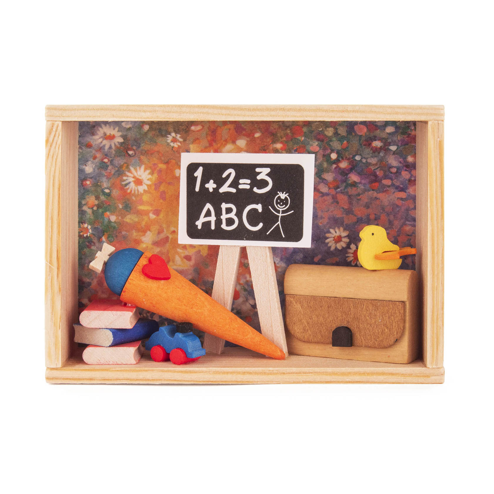 Ein kleines Holzkästchen enthält eine Minischultafel mit der Aufschrift '1+2=3, ABC', eine orangefarbene Schultüte, Holzspielzeug und ein gelbes Entlein.