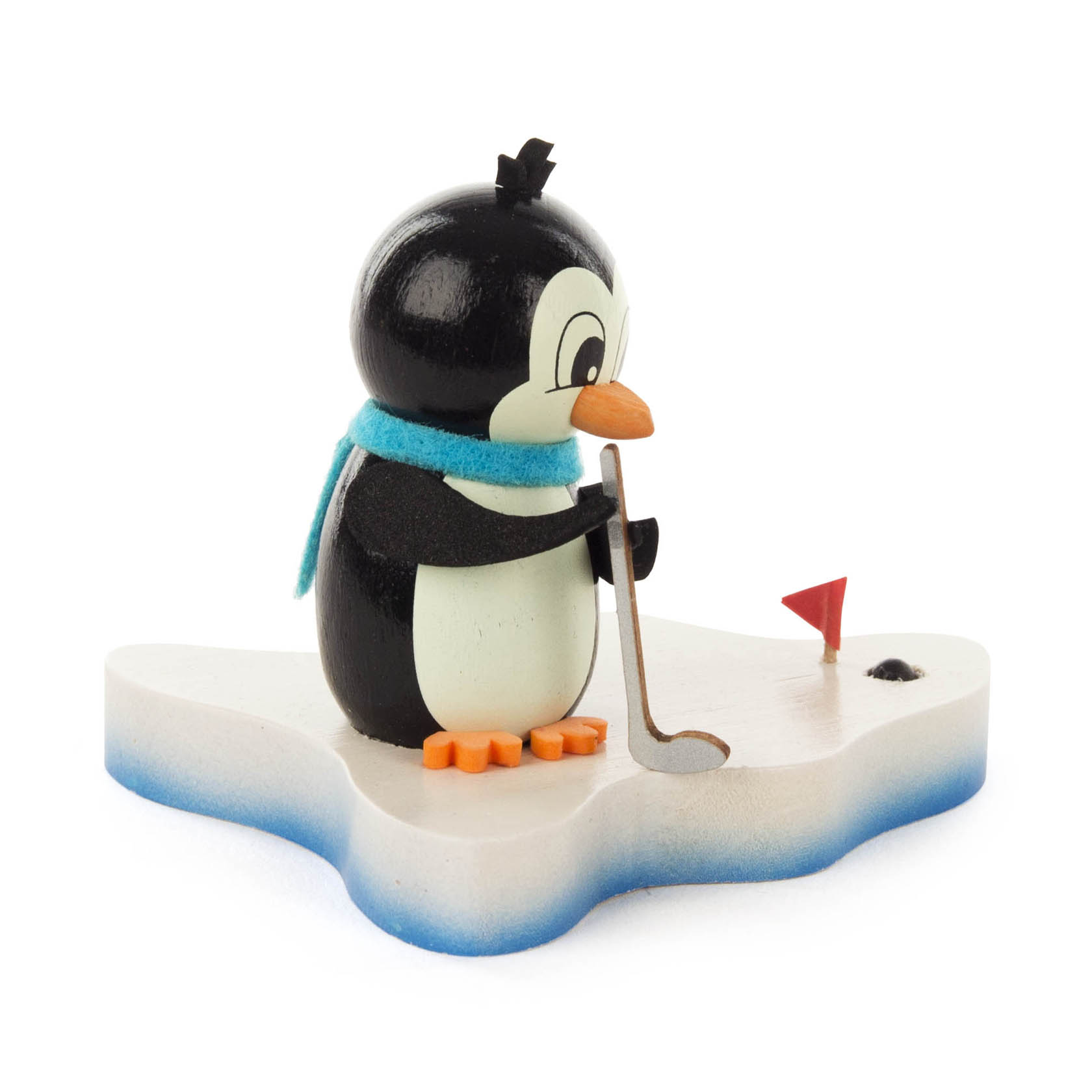 Holzfigur eines Pinguins mit blauem Schal, der auf einer eisförmigen Basis steht und einen Golfschläger mit einem kleinen Loch daneben hält.