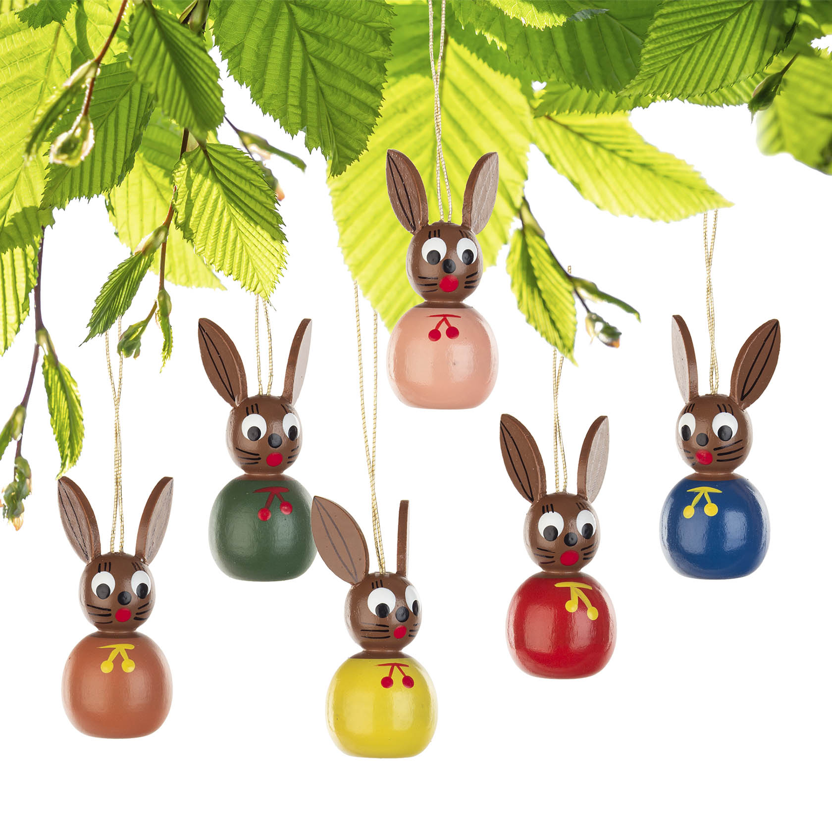 Sechs bunte Osterhasen-Anhänger mit langen Ohren und Gesichtsmalereien, die an grünen Blättern hängen.
