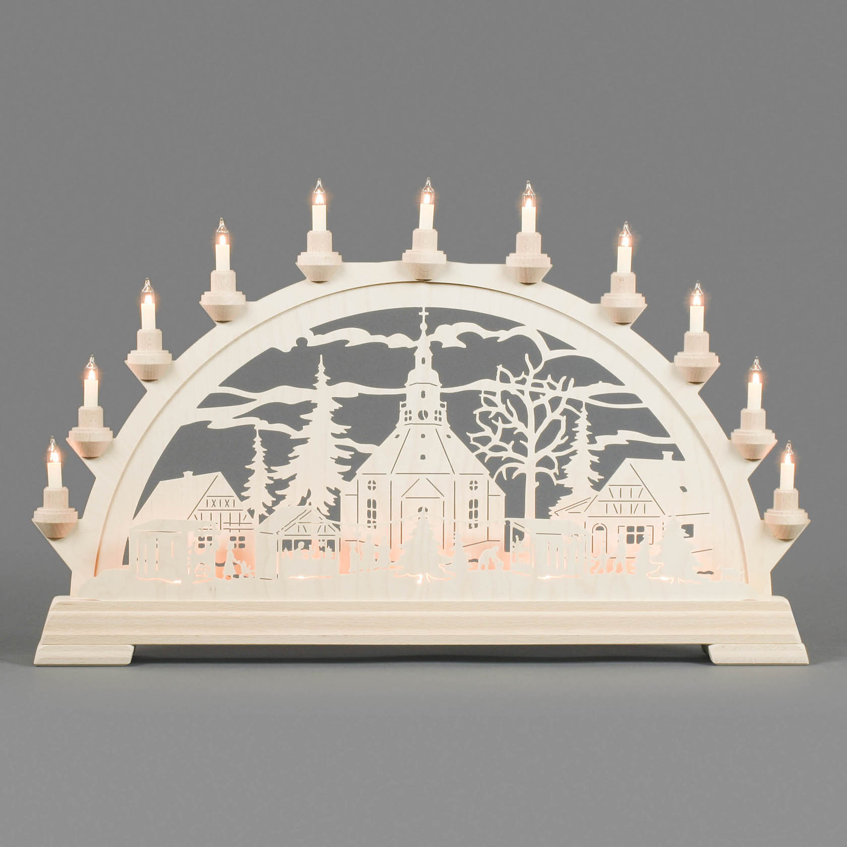 Elektrisch beleuchteter Schwibbogen mit Seiffener Weihnachtsmarkt, zeigt Detail der Kirche und Stände in filigranem Holzschnittdesign.