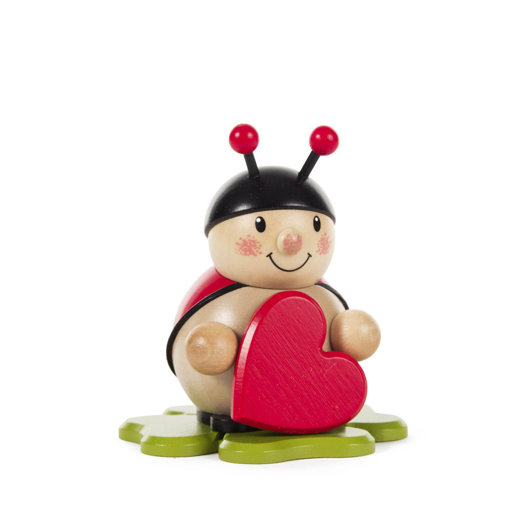 Holzfigur eines lächelnden Marienkäfers mit roten Wangen, der ein rotes Herz in den Händen hält. Er sitzt auf einer grünen Blattform. im Dregeno Online Shop günstig kaufen