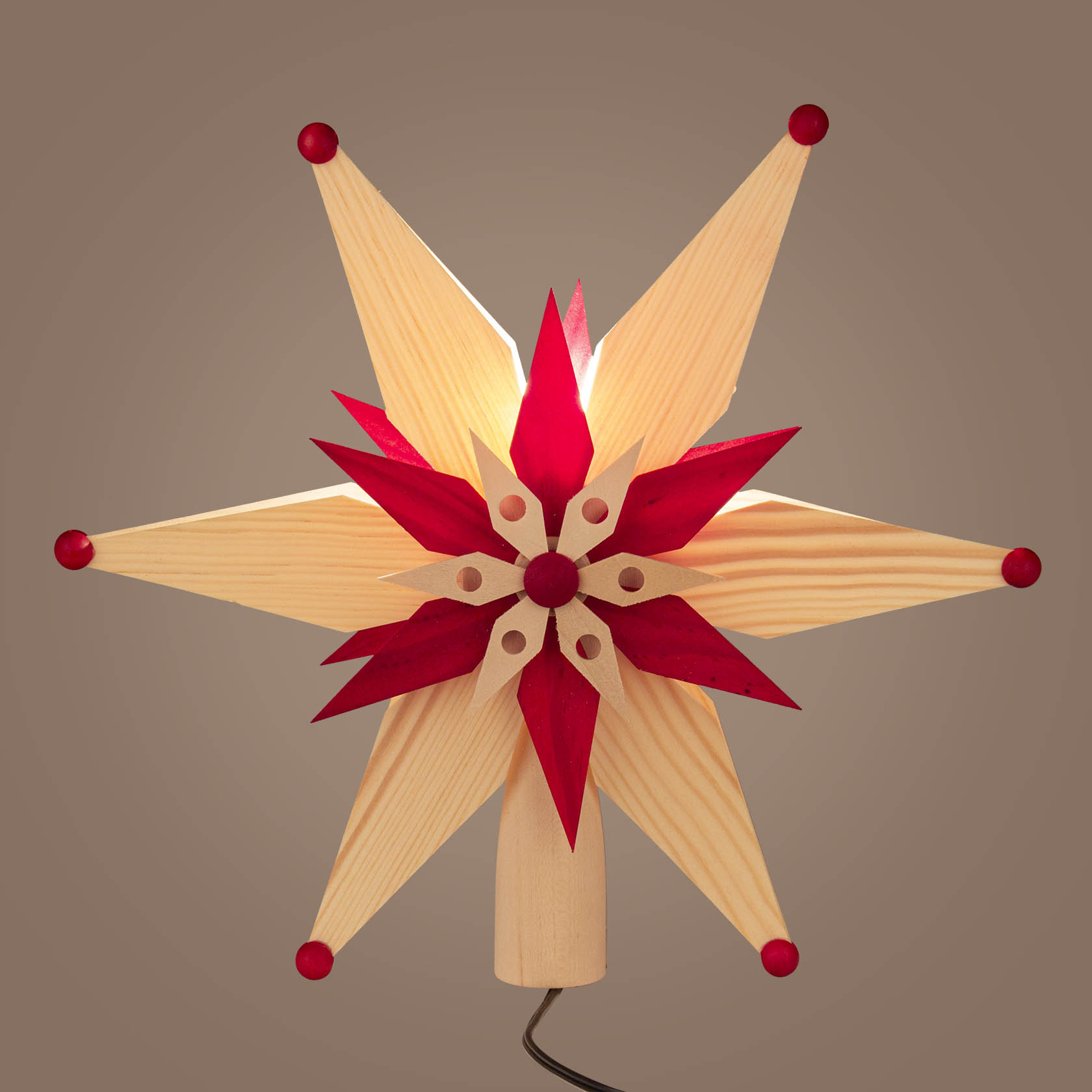 Roter und naturfarbener Spanstern als Christbaumspitze mit elektrischer Beleuchtung.