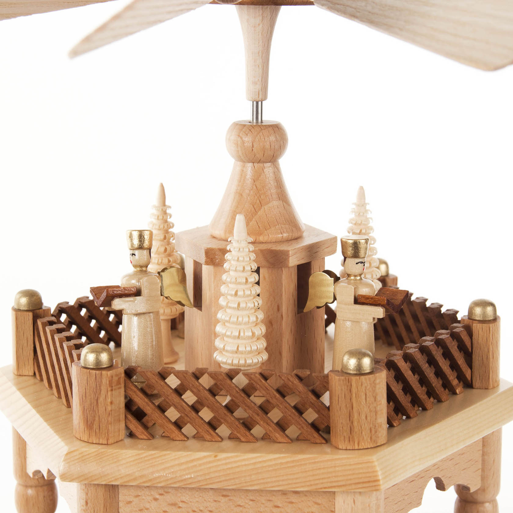 Holzpyramide mit einem Stockwerk, das die Geburt Christi darstellt, umgeben von vier Engeln mit Musikinstrumenten und Tannenbäumen.