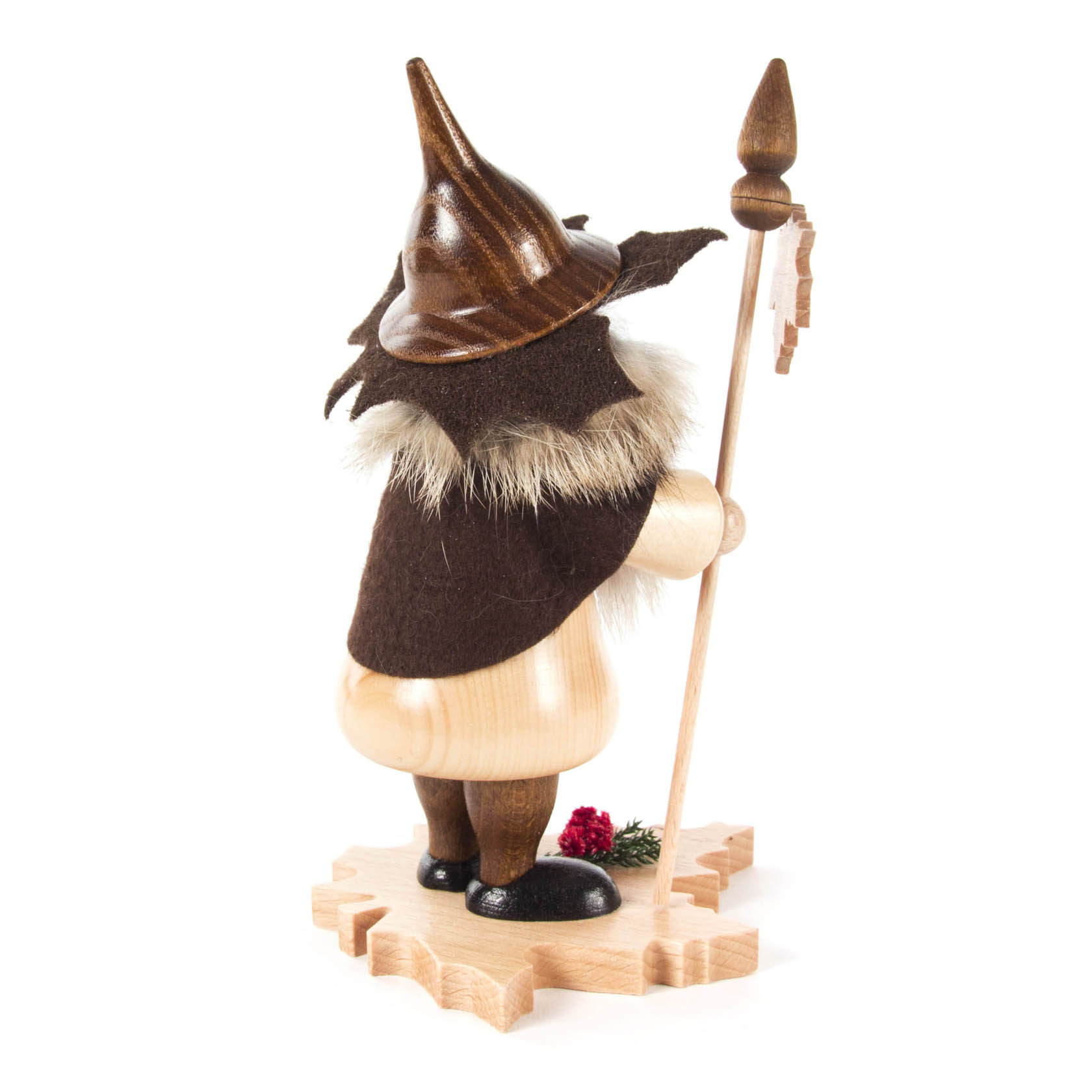 Ein handgefertigter Räuchermann zeigt einen Baumwichtel mit spitzem Hut und Bart, der auf einem Ahornblatt steht und einen Stock hält.