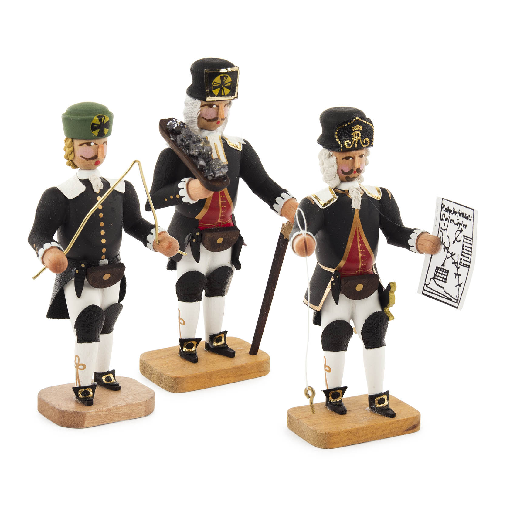 Drei Holzfiguren in Bergmannsuniform: ein Wünschelrutengänger mit Rutenzweig, ein Knappschaftsältester mit Kohlenstück und ein Markscheider mit Plan. im Dregeno Online Shop günstig kaufen