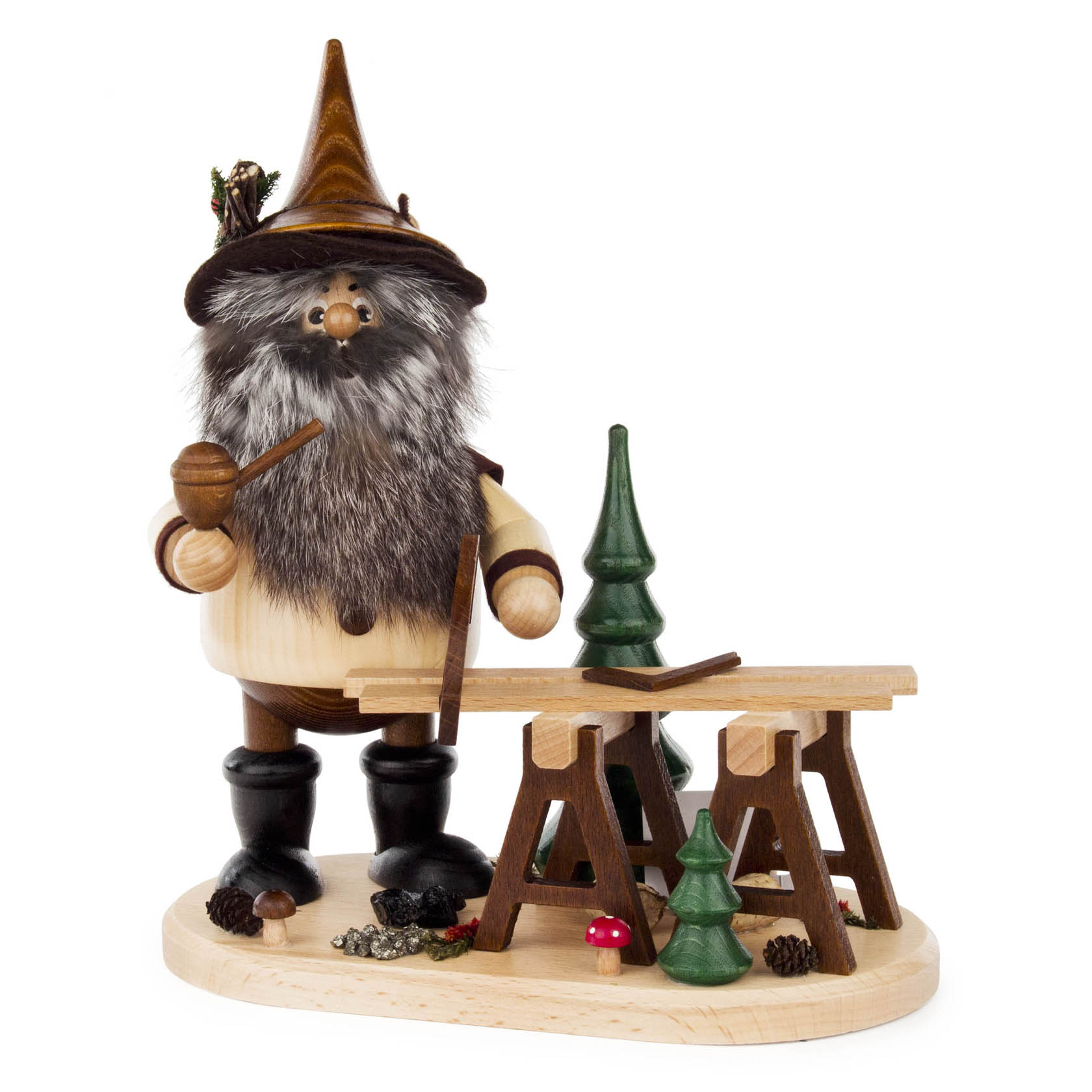 Räuchermann-Figur eines bärtigen Bergzimmermanns mit Pfeife und Hut, vor einer Werkbank mit kleinen Bäumen, auf einem Holzboden stehend. im Dregeno Online Shop günstig kaufen